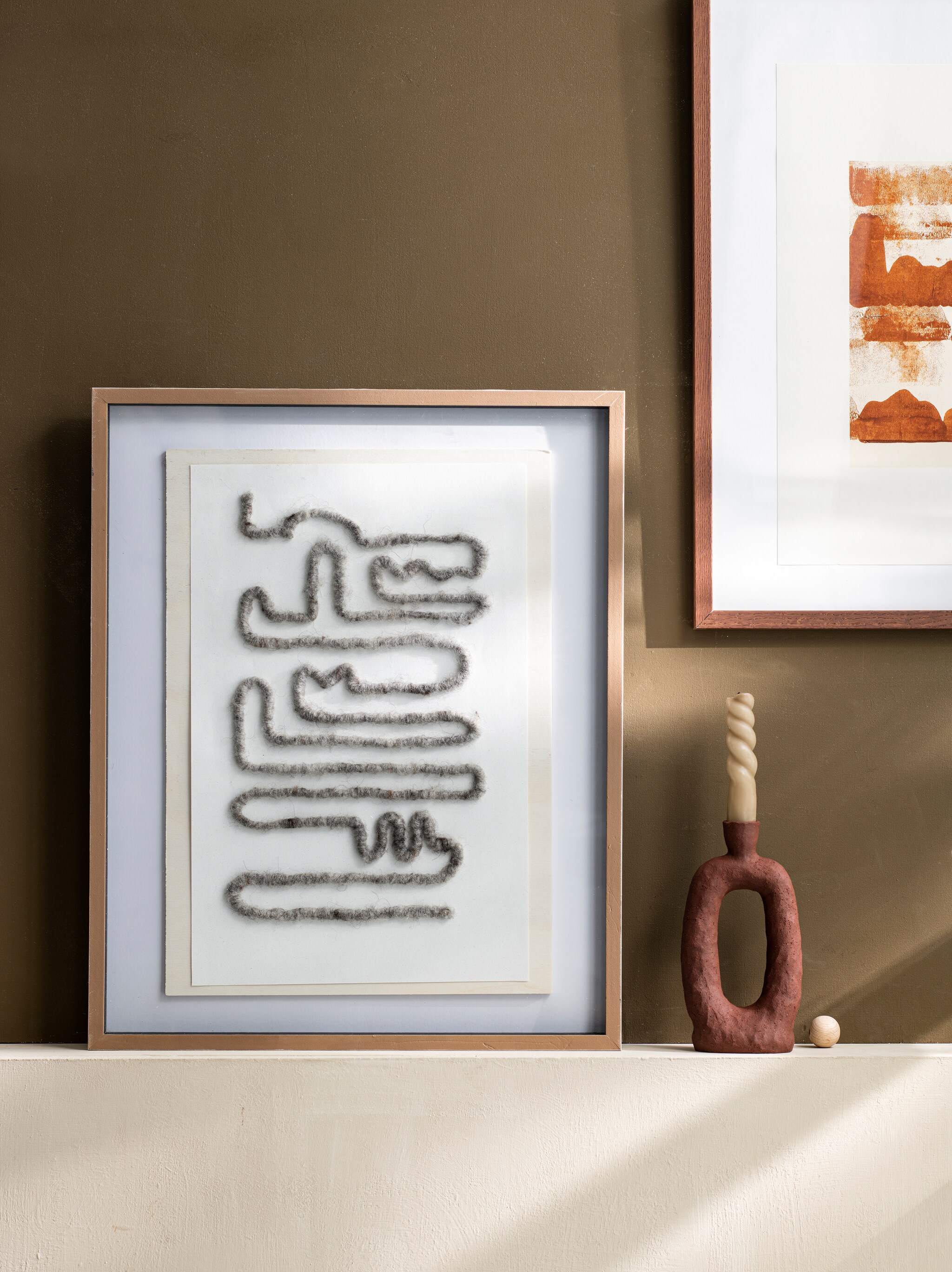 Art print Earth 02 € 49,-, lijst Dark Oak vanaf € 19,-, kandelaar van Malwina Kleparska € 120,- (thefinestore.com). Overig privébezit. vtwonen 08-2022 | styling Myla Griese | Fotografie Louis Lemaire