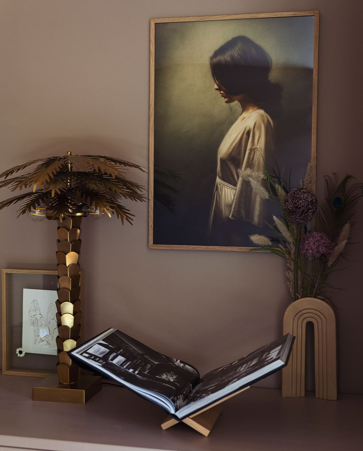 Schilderij Werk aan de Muur.Tafellamp palmboom HKliving. Fotolijstje Amber de Vreng. Vaas Karwei. Boekenstandaard Zara Home. vtwonen 10-2021 | styling Ilona Jongepier | fotografie Dana van Leeuwen