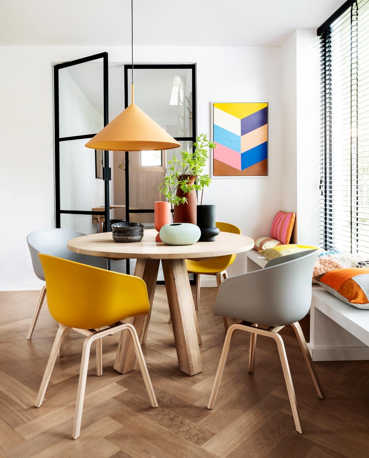 Eettafel Alaska, 120×78 cm (Øxh) € 1095,-(hetkabinet.nl). Eetkamerstoelen About a Chair van Hay in Mustard en Concrete Grey per stuk € 249,- (vtwonen.nl). Hanglamp Triangle, 60×39 cm (Øxh) € 239,-, schilderij Colourful Strokes € 139,95, oranje-roze gestreept kussen € 47,95, perzik-crème gestreept kussen € 34,95, koraalrode vaas Suites Special € 27,95 (hkliving.nl). Wollen kussen Multi € 39,95, zwarte vaas Corsica € 17,50, borden Odile per stuk € 10,-, ovale mintkleurige vaas € 16,95 (loods5.nl). Kussen met oranje vlakken € 115,- (kus-sen.nl). Overig privébezit. vtwonen 08-2020 | Fotografie Stan Koolen, styling Moniek Visser