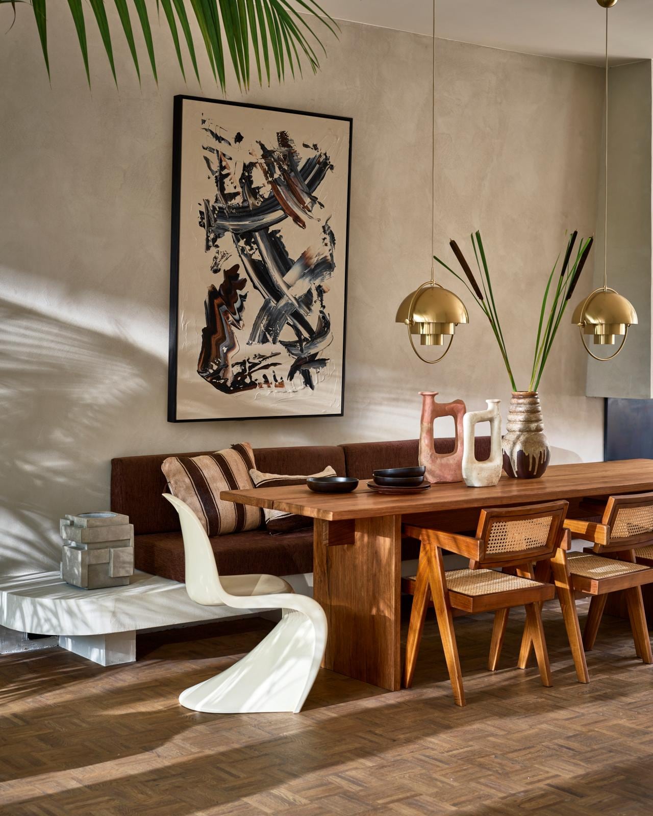 Op maat gemaakte tafel van frakéhout, prijs op aanvraag (@takumi_interior). Abstract schilderij van Patrick van Riemsdijk (patrickvanriemsdijk.com). Tamegroute vaas, klein € 115,-, groot € 138,- (householdhardware.nl). Houten armstoelen Detjer Office Chair, € 425,- (casagitane.com). Hanglampen Multi Lite Pendant Large Brass van Gubi, € 839,- (nordicnew.nl). Vintage jaren 70- vaas € 50,- (vandijkenko.nl). Witte kunststof stoel Panton Chair van Verner Panton uit 1974, € 750,- (neeflouis.nl). Donkerbruine keramische borden Home Chef, diep € 16,95, plat € 17,95 (hkliving.nl). Betonnen wijnkoeler € 149,- (serax.com). Bruin/beige gestreept kussen, 50×60 cm € 149,-, bruin/beige gestreept kussen, 60×40 cm € 149,- (couleurlocale.eu). vtwonen 09-2021 | styling Cleo Scheulderman | fotografie Jeroen van der Spek
