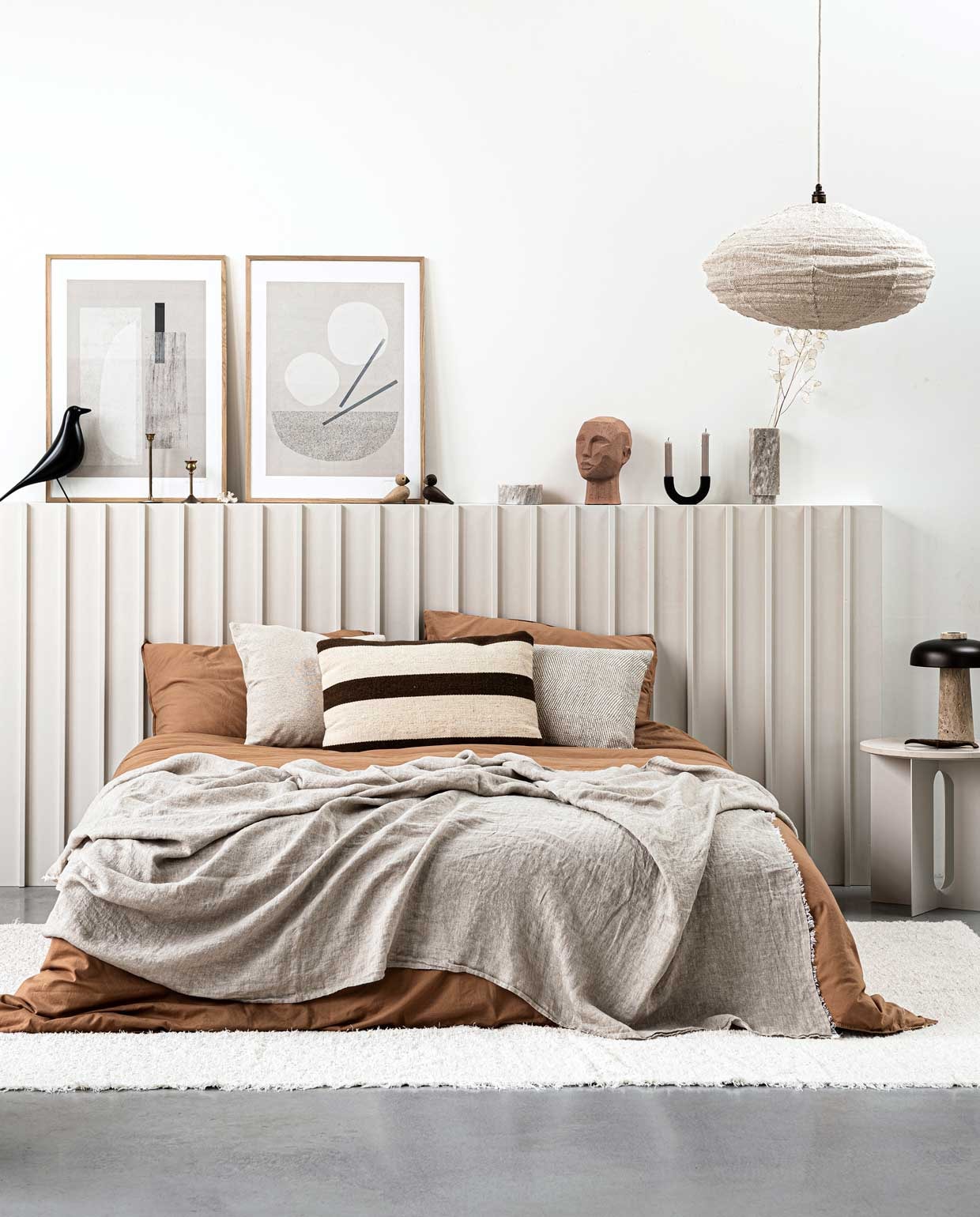 zwart houten object Eames’ House Bird van Vitra € 175,-, houten objecten Lovebirds van Kay Bojesen per twee € 83,-, sculptuur hoofd € 32,95, grote poster in houten lijst van HKliving, 95x75x2,5 cm (hxbxd) € 219,-, zwarte kandelaar Arch van Ferm Living € 45,99 (vtwonen.nl). Marmeren pot met deksel € 19,99, marmeren vaas € 39,95, pyjamajasje en short € 39,99 (hm.com). Posters van Julia Hallström Hjort, links Carrarra, rechts Miso, 50×70 cm € 89,-, eikenhouten lijst € 69,- (theposterclub.com). Stoffen hanglamp Kapok Tree in Natural/Beige € 108,- (thebizzcollection.com). Linnen strijkijzersnoer per meter € 5,20, bronzen fitting € 13,50 (snoerboer.nl). Dekbedovertrek 240×220 cm € 95,-, kussenslopen 60×70 cm per twee € 30,-, beide 100% katoen in kleur Dromedary (midnatthome.com). Tafellamp met travertin voet en brons aluminium kap Reverse van Aleksandar Lazic, 24/10×30 cm (Øxh) € 550,-, bijzettafel Androgyne van Danielle Siggerud, 40×43 cm (Øxh), met marmeren tafelblad 42×1,8 cm (Øxh) € 449,- (menuspace.com). Linnen plaid in kleur Flax, 145×270 cm € 149,- (bymolle.com). Wollen kussen met bruine streep 40×60 cm € 64,-, linnen kussen 40×60 cm € 45,- (loods5.nl). Beige kussen 45×45 cm € 11,99, vloerkleed 200×300 cm € 169,- (zarahome.com). Overig privébezit. vtwonen special DIY 1 | styling Kim van Rossenberg | uitvoering Richard van Meerveld | fotografie Sjoerd Eickmans