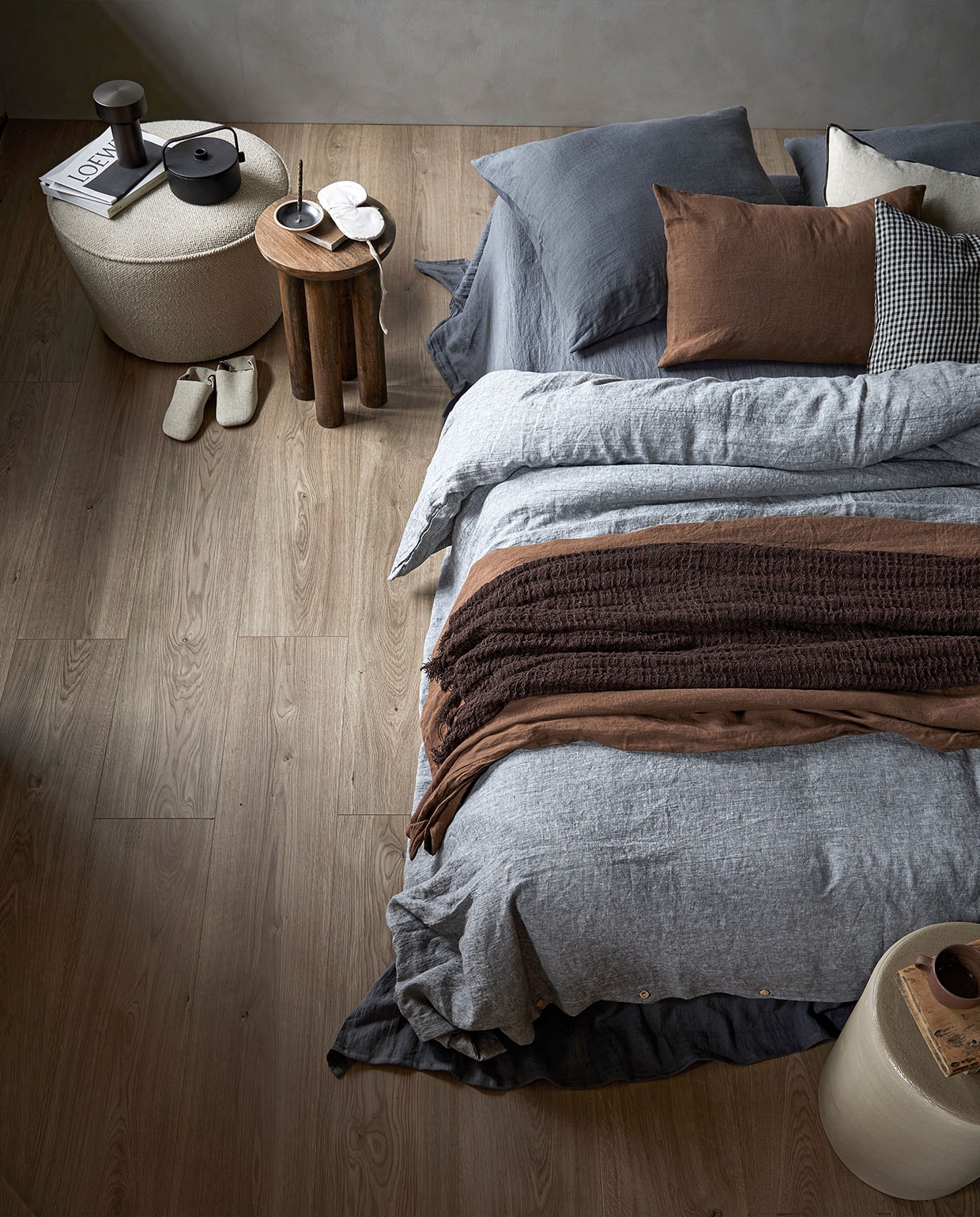 EVC-vloer Spelled, per m² € 63,99M.m.v. pure-original.nl (muurverf Fresco in kleur Soft Taupe), designtales.nl (bouclé poef, tafellamp), letoile.store (gietijzeren theepot, keramieken wierookhouder, stenen onderzetter), nordal.eu (houten bijzettafel, slaapmasker, donkerbruine wafeldeken), bymolle.com (linnen dekbedovertrek in kleur Pebble, linnen laken in kleur Slate, linnen kussens in kleur Slate en Cacao, linnen plaid in kleur Cacao), paviljoen-noord.com (geruit kussen), loods5.nl (keramieken kruk). Overig privébezit. vtwonen 07-2022 | productie Tanja Saarberg | styling danielle Verheul | fotografie Peggy Janssen | assistentie Kula van den Broek\n