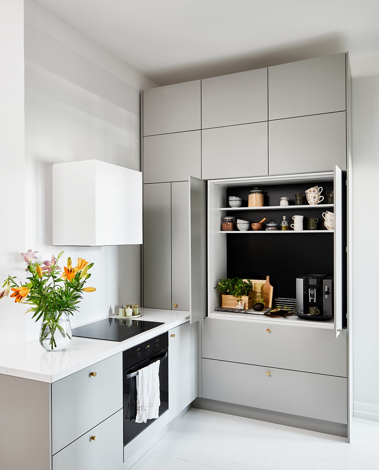 Keuken met inschuifdeuren op maat gemaakt door Blau Interior, geverfd in kleur ON.00.76 van Flexa. De houten vloer is wit geverfd. vtwonen special tiny houses 2021 | productie Living Inside | fotografie Krista Keltanen