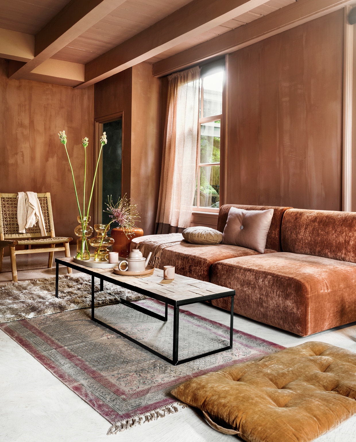 Elementenbank Bow van Cassina in sleetse velours Gordon, vanaf € 2150,- per element (frozenfountain.com). Keramieken ronde bijzettafel van Marie Michielssen vanaf € 345,- (serax.com). Fauteuil van touw en hout € 700,- (sukha.nl). Stalen salontafel met blad van terra tegels, 165×42,5×34 cm, vanaf€ 795,- (boxworx.nl). Hoogpolig vloerkleed 180×120 cm € 439,- (hkliving.nl). Vaal kleed met print, 180 x120 cm € 195,-(iblaursen.dk). Matraskussen van geel velours € 62,- (deens.nl). Gordijn van linnen Sutton House Reloaded, kleuren CH2351/022 en 023 van Chivasso, kamerhoog, breedte 310 cm per meter€ 144,50 (jab.de). Op de bank: plaid van Malagoon € 39,95, rechthoekig kussen van Hay € 79,- (eijerkamp.nl), rond kussen van Madam Stoltz € 34,50 (vtwonen.nl). Op tafel: ovaal zandkleurig dienblad van Serax € 61,-, zalmkleurig dienblad van Bloomingville € 24,95, theepot van Normann Copenhagen€ 80,50, glazen vazen van Mica, € 26,95 en € 27,95, (vtwonen.nl). Mokken met oor van hkliving € 7,75 (eijerkamp.nl). Kalkverf kleur Cypria, per liter vanaf€ 45,85 (brechtmurreatelier.nl). vtwonen 08-2019 | styling Marianne Luning | fotografie Stan Koolen