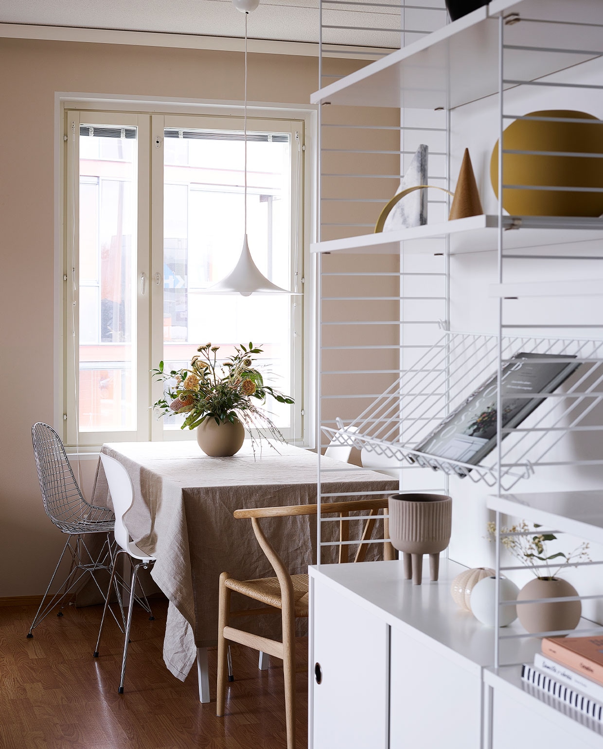 Wandrek String. Eettafel van maatwerkblad op schragen van Hay. Stoelen Vitra (metaal) en Flinders (hout). Vazen en kommen Cooee. Hanglamp Gubi. NEE | vtwonen binnenkijken special 12-2021 | productie Living Inside | fotografie Krista Keltanen | tekst Jonna Kivilathi | tekstbewerking Christine van der Hoff