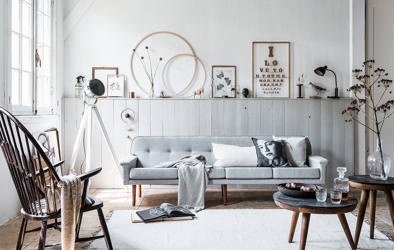 Verf lambrisering Pavilion Gray No 242, Estate Emulsion (). Grijs gemêleerde 4-zits bank Ervee, oude bureaulamp (). Fauteuil Windsor, vloerkleed van vtwonen, salontafel Trident zwart marmer, plaid Alpaca, kussen met portretfoto van Zusss, linnen kussen van Zusss, sjaal van Zusss, afbeelding fiets Wall Art Carl, houten letterbak (). Fabriekslamp, oude lijst, houten oude klos, vogel (). Houten lijst van Moebe met poster, houten lijst van Moebe met poster, transparante lijst, vaas met gouden rand van Nordal, beeldje Love Warrior, fles met takje Etnic, zwart kinderkopje, boek Oscar (). Muurornament Mobile van House Doctor, gouden lijst Framed Lettering van Anna+Nina, houten paard van , Kay Bojesen, kussen Almond van van By Mölle, (). Houten hoepels (). Whiskyfles, whiskyglazen (). Roomspray (). Bril (). Oude lijst en onderste boek (kringloop). Overig privébezit. vtwonen 08-2017 | styling Kim van Rossenberg | fotografie Sjoerd Eickmans