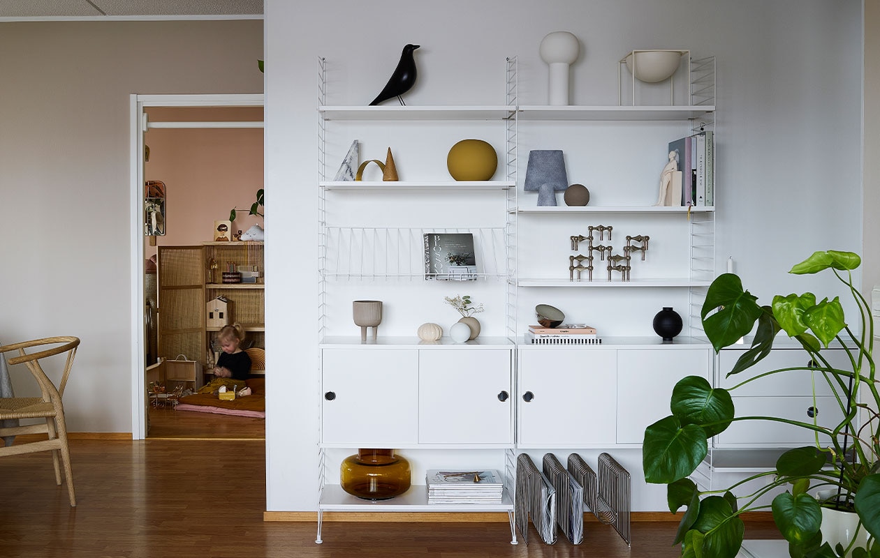 Wandrek String. Vogel Vitra. Beelden Kristina Dam Studio. Kandelaar Stoff Nagel. Vazen en kommen Cooee. Tijdschriftenrek op vloer Aytm. Stoel van Hans Wegner via Flinders. NEE | vtwonen binnenkijken special 12-2021 | productie Living Inside | fotografie Krista Keltanen | tekst Jonna Kivilathi | tekstbewerking Christine van der Hoff