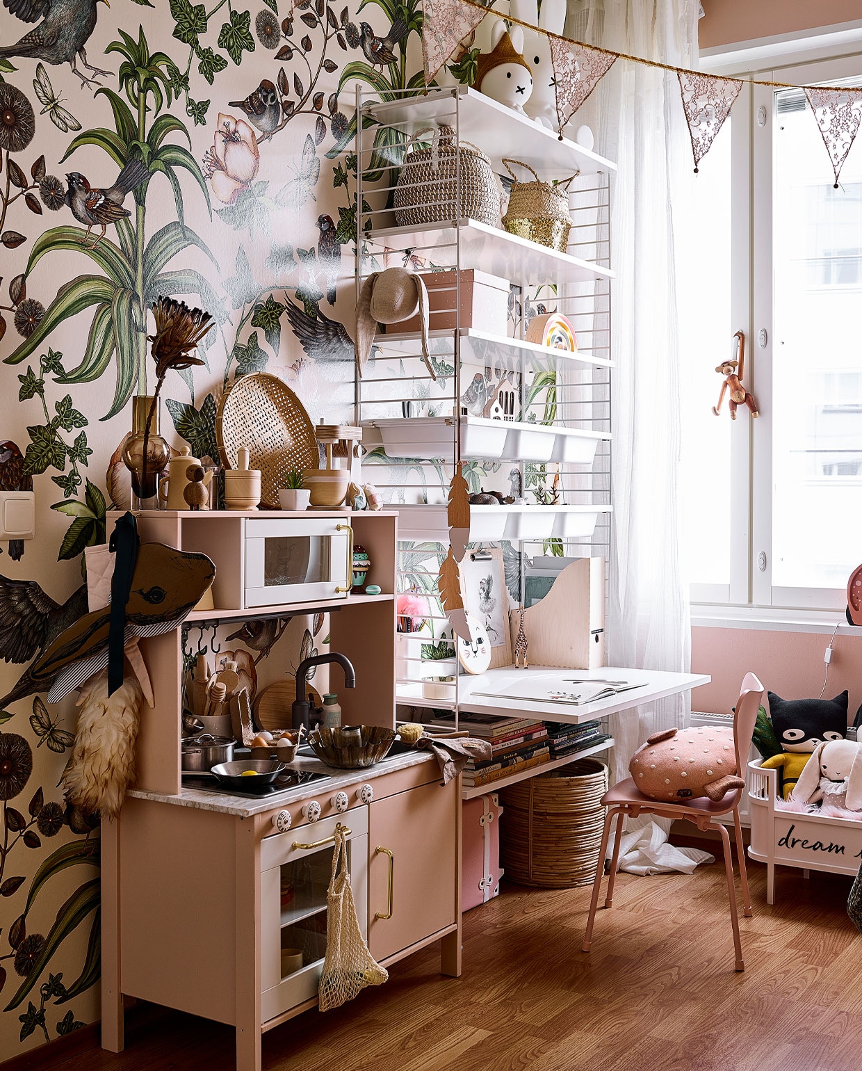 Vergelijkbaar behang Trending Wall en Studio Poppy. Wandrek String. Speelgoedkeuken Ikea, zelf geverfd en van nieuw blad en grepen voorzien. Cakevorm erfstuk. Vergelijkbare houten mixer Kids Concept, overig keukengerei onbekend. Nijntje-lampen De Winkel van Nijntje. Roze Vlinderstoel Mister Design. Aap van Kay Bojesen Vitra. Poppenbed Sebra. Superheldenknuffel en konijn Studio Bundis. NEE | vtwonen binnenkijken special 12-2021 | productie Living Inside | fotografie Krista Keltanen | tekst Jonna Kivilathi | tekstbewerking Christine van der Hoff