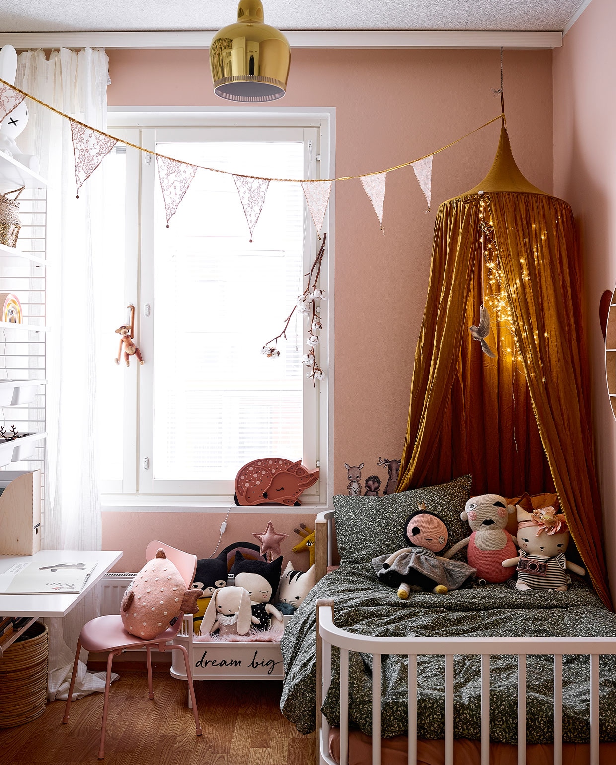 Muurverf Setting Plaster Farrow &amp; Ball. Roze vlinderstoel Mister Design. Stippenkussen onbekend. Bed Oliver Furniture. Poppenbed Sebra. Stoffen poppen Lucky Boy Sunday en Studio Bundis. Hemel Lidor. Hanglamp Artek. Vlaggenlijn en hert onbekend. NEE | vtwonen binnenkijken special 12-2021 | productie Living Inside | fotografie Krista Keltanen | tekst Jonna Kivilathi | tekstbewerking Christine van der Hoff