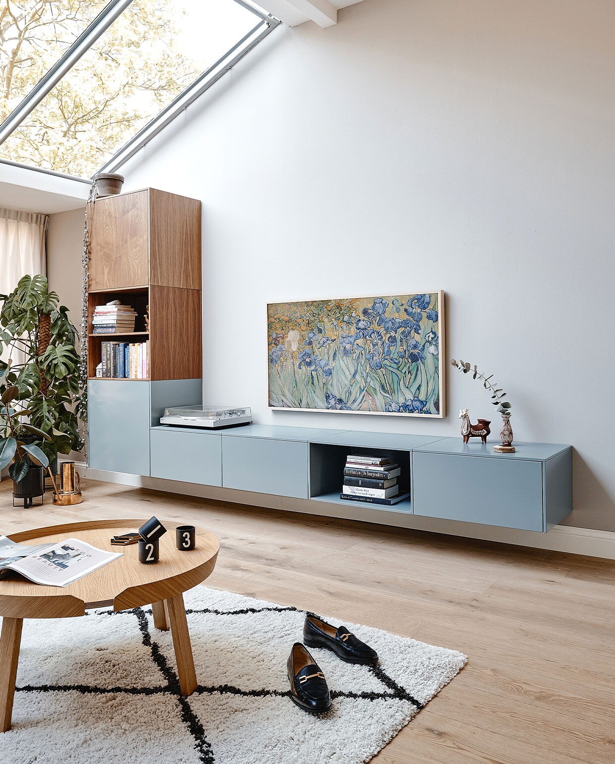 Muurverf Ammonite van Farrow &amp; Ball. Wandkast NoNoo in donker hout en verfkleur De Nimes van Farrow &amp; Ball. Platenspeler van Maartens vader. Televisie The Frame van Samsung met eikenhouten lijst en Van Goghs Irissen als achtergrond. Peruaans lamabeeld van Maartens ouders. Zwarte plantenpot Ferm Living, gieter Divan Tivoli, vloerkleed Benuta, salontafel Muuto, kopjes Design Letters. Loafers Unisa. vtwonen 05-2022 | productie Cocofeatures | fotografie Roos Oosterbroek