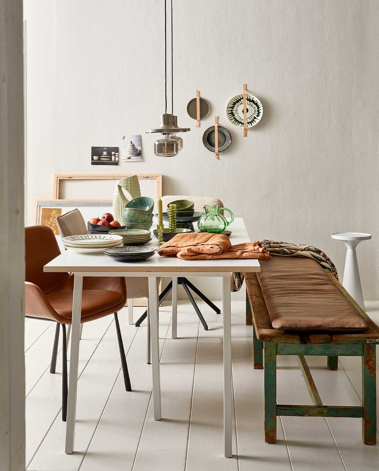 Tafel Loop Stand van Hay, 180×87,5×180 cm (bxl) € 769,-, servies van voor naar achter: bord met gestreepte rand, 21,5 cm (Ø) per 4 € 35,80 (ook aan de wand), witte borden met groene streep, 28 cm (Ø), per stuk € 26,95 (ook aan de wand), zeegroen bord, 20,5 cm (Ø), per stuk € 17,60, diep bord met appels, 30 cm (Ø), per stuk € 17,30, zeegroene kom, 16 cm (Ø), per stuk € 18,10, donkergroen bordje met geschulpte rand, 18 cm (Ø), per stuk € 19,75 (ook aan de wand), linnen tafelkleed Gracie van Broste Copenhagen, 160×300 cm € 76,99, plaid op bank, 130×160 cm € 21,65 (vtwonen.nl). Groene schaal op voet, 30 cm (Ø) € 79,95, erop groene kom, 16 cm (Ø), per 2 € 23,95, groene glazen kan, 16×15 cm (Øxh) € 34,95, glazen kandelaar vanaf € 17,95, geribbelde vaas 32 cm (h) € 59,95 (hkliving). Leren kussen, 40×180 cm € 329,- (nahka.nl). Hanglamp Skye, 20 cm (Ø), per stuk € 75,-, stoel Tyler op kruispoot € 379,- (zuiver.com). Houten bankje € 75,- (vandijkenko.nl). Foto’s privébezit. vtwonen 05-2022 | Styling Fietje Bruijn | Fotografie Dennis Brandsma\n