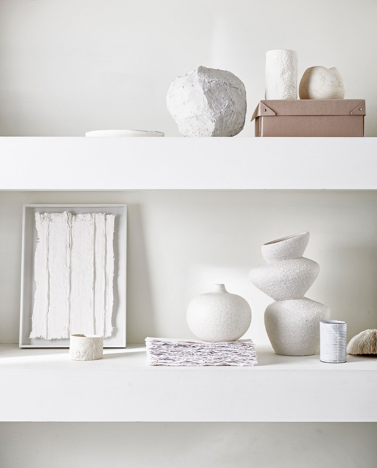 Bovenste plank van links naar rechts: mat wit bord € 12,99 (zarahome.com), papier-maché vaas prijs op aanvraag (julyadrichem.com), grove keramieken pot € 12,99 (zarahome.com), witte keramieken bolvaas € 95,- (annemiekebootsceramics.nl). Onderste plank van links naar rechts: kunstwerk in lijst € 450,- (julyadrichem.com), keramieken mok € 22,90, witte bolvaas € 49,99 (letoile.store), grove keramieken vaas € 29,99 (hm.com). Overig privébezit. vtwonen 06-2022 | Styling Danielle Verheul | Fotografie Sjoerd Eickmans | Assistentie Sanne Ketelaar, Minke van Bakel