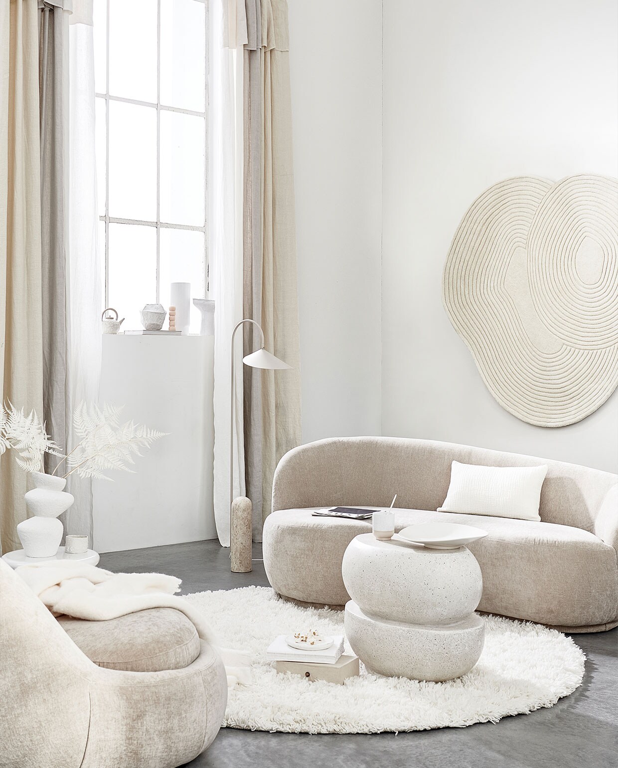 Fauteuil, 176x100x74 cm (bxdxh) € 599,-, bank € 999,- (sofacompany.com). Gordijnen gemaakt van linnen stof Brera Lino in kleur Calico, Putty en Oyster van Designers Guild, per meter € 86,- (wva.nl). Vloerkleed van Linie Design € 700,-, witte bijzettafel van Pols Potten € 294,99, vloerlamp van Ferm Living € 679,- (vtwonen.nl). Wollen plaid € 119,-, keramieken theepot € 25,99, wit kussen € 39,99 (zarahome.nl). Keramieken vaas € 29,99 (hm.com). Witte keramieken mok € 22,90 (letoile.store). Geometrische vaas en schaal op voet prijs op aanvraag (julyadrichem.com). Handgemaakte bolletjeskaars, set van drie € 45,- (sukha.nl). Porseleinen vaas € 87,-, vloerkleed aan wand € 630,-, witte keramieken mok met ongeglazuurde onderkant, set van twee € 27,- (bolia.com). Betonnen bijzettafel € 450,- (lanena-home.com). Witte keramieken schaal € 44,95 (urbannatureculture.com). Overig privébezit. JA | vtwonen 06-2022 | styling Danielle Verheul | fotografie Sjoerd Eickmans | assistentie Sanne Ketelaar, Minke van Bakel
