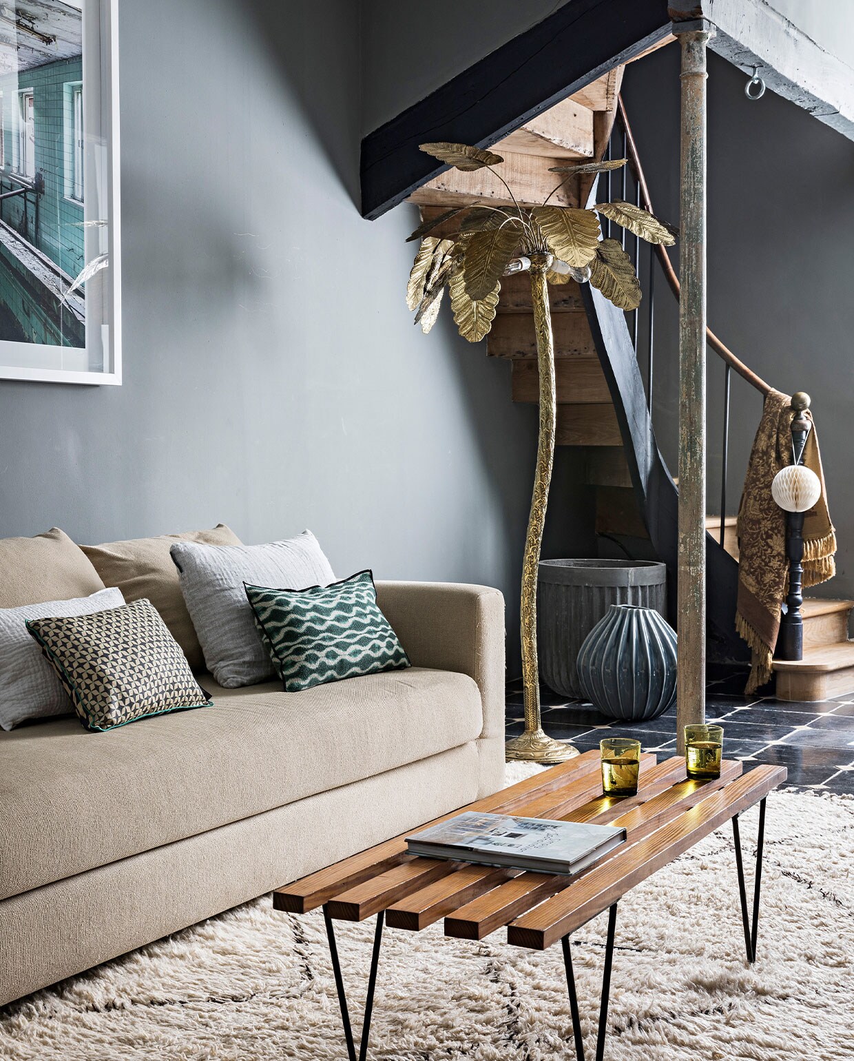bank uit de jaren 80 geërfd van de familie. Kussens Le Monde Sauvage, fifties salontafel van een lokale vintagehandelaar, remake van een palmboomlamp van Maison Jansen, fotokunst uit de serie Chernobyl van Felix Forest. Muurverf van Reca. NEE | vtwonen 4-2022 |  styling  Marie-Maud Levron | fotografie Yann Deret | tekst Anne-Catherine Scoffoni | tekstbewerking Chris Muyres