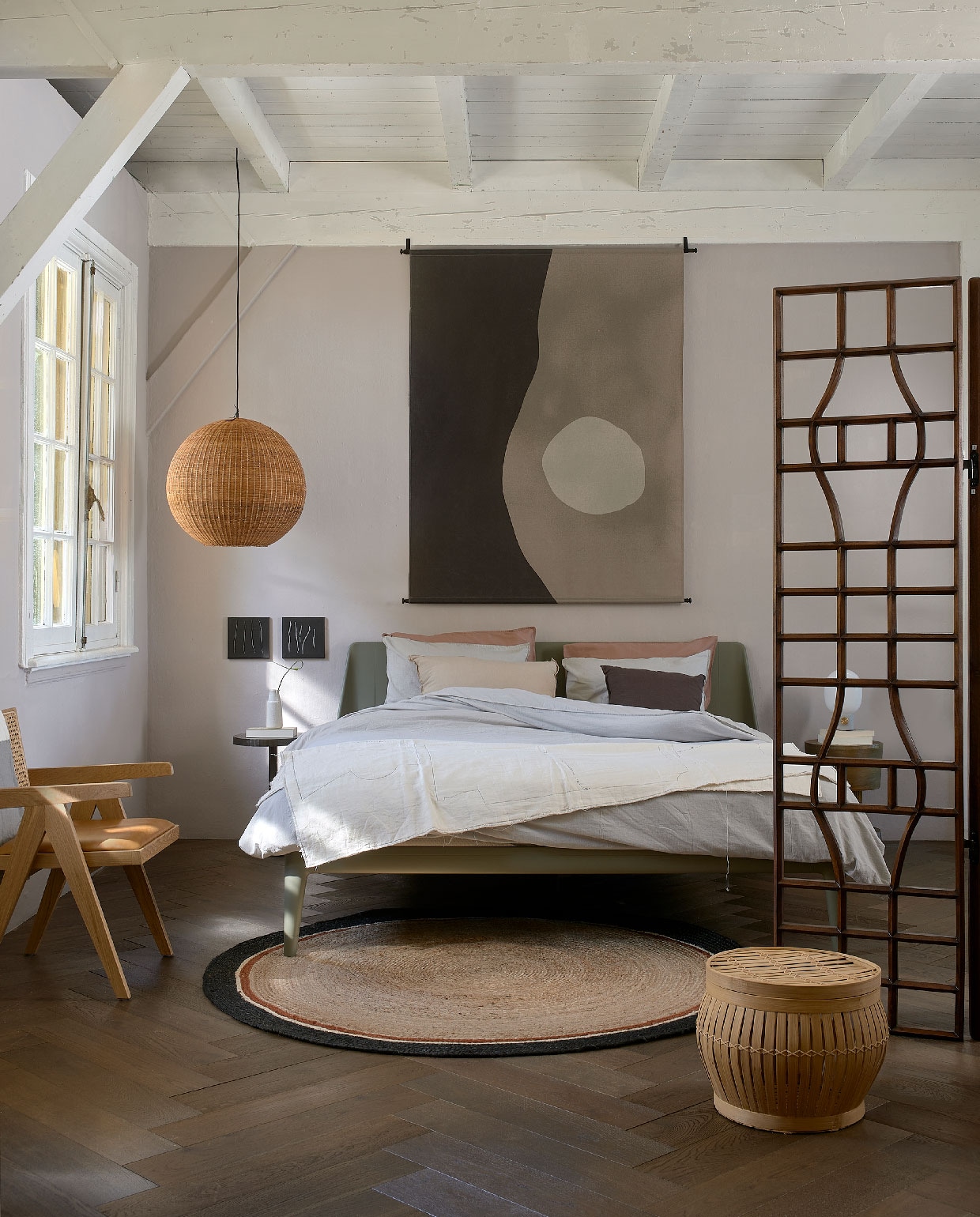 Slaapkamer ingericht in Japandi stijl. Muurverf Skin van vtwonen, per 2,5 l € 32,99 (karwei.nl). Stoel € 199,-, kleed € 47,50 (loods5.nl). Kamerscherm Mango € 899,- (polspotten.nl). Plaid op bed € 359,-, kaftan over stoel € 229,-, kunstwerken ingelijst vanaf € 189,- (sukha.nl). vtwonen 10-2020 | styling Fietje Bruijn | fotografie Dennis Brandsma