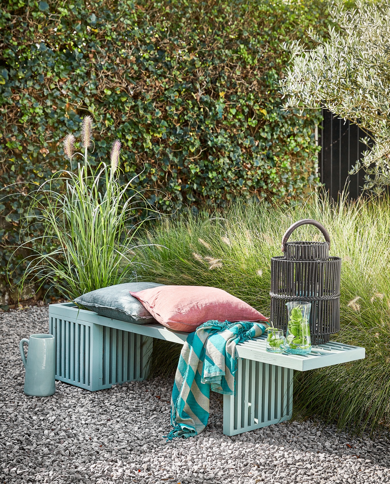 Lichtblauwe waterkan € 42,50 (loods5.nl). Linnen kussens € 49,95 per stuk (nijhof-baarn.nl). Gestreepte plaid Candy Stripe € 34,99 (sissyboyhomeland.com). Zwarte tuinlantaarn Bartolone € 139,-, grijze plantenbak in de bank € 29,99 (intratuin.nl). Glazen karaf € 17,95, glas met oor € 3,95 (householdhardware.nl) vtwonen tuin 3: productie Corrien Flohil | uitvoering Johan Snoodijk | styling Moniek Visser | fotografie Peggy Janssen