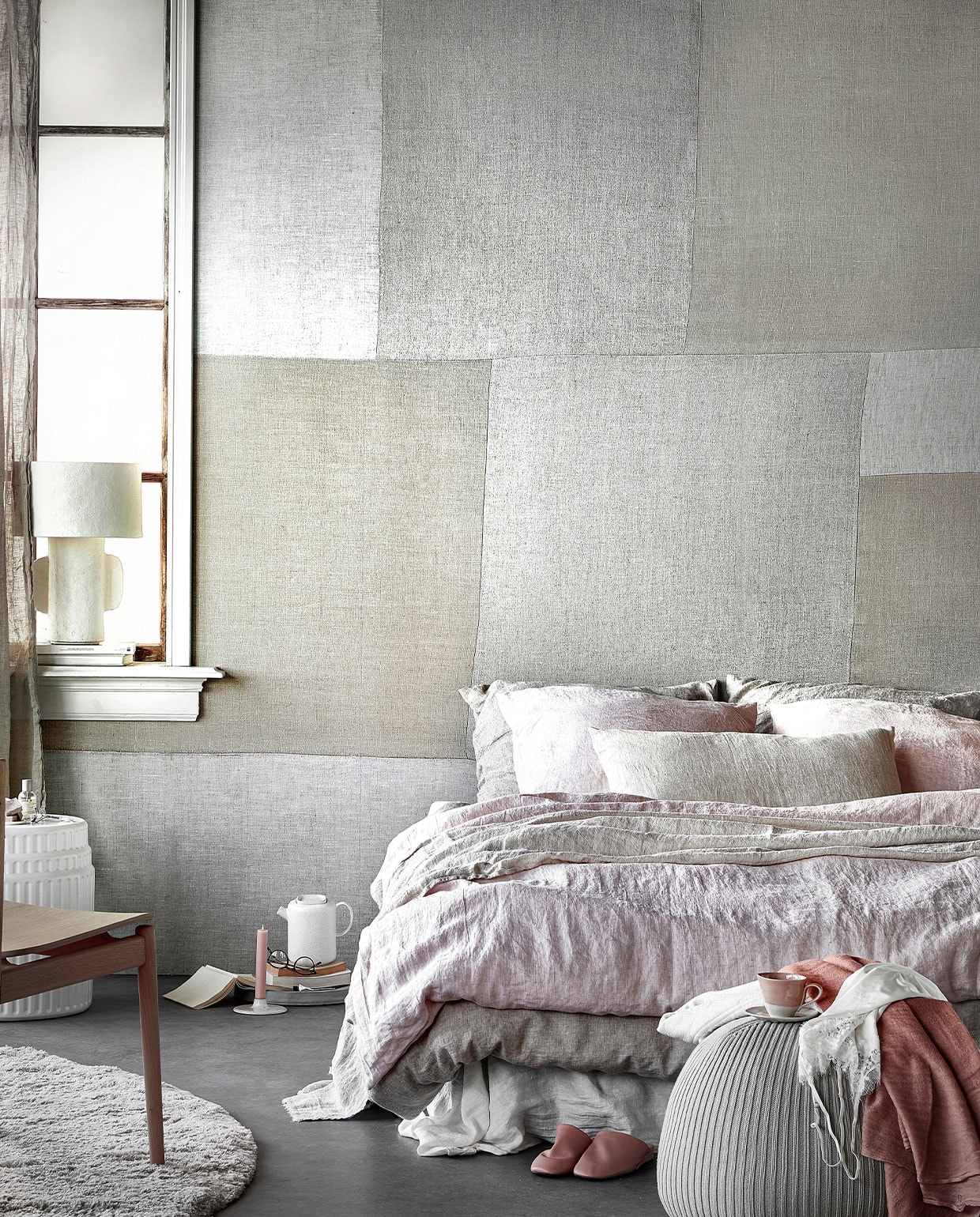 Digitaal behang Patchwork Fabric, 6 banen van 280×50 cm, totaal (lxb) 280×300 cm. M.m.v. hm.com (linnen gordijnen), paviljoennoord.com (papier-maché lamp, vest, roze shawl, kanten hemdje), kasstoor.nl (wit keramieken bijzettafel, rond vloerkleed), bolia.com (houten stoel, theepot), letoile.store (kandelaar), homestede.nl (betonnen schaal, poef), zara.com (roze kop-en-schotel, roze leren instappers), bymolle.com (wit laken in kleur Pure White, linnen dekbedovertrek in kleur Flax, linnen dekbedovertrek in kleur Blush, linnen plaid in kleur Sea Shell, linnen kussenslopen in kleur Blush en Flax), pure-original.nl (lakverf in kleur Ashes). Overig privébezit. JA vtwonen 05-2021 | styling Danielle Verheul | productie Tanja Saarberg fotografie Peggy Janssen | assistentie Niels Kist, Danique van Rijn