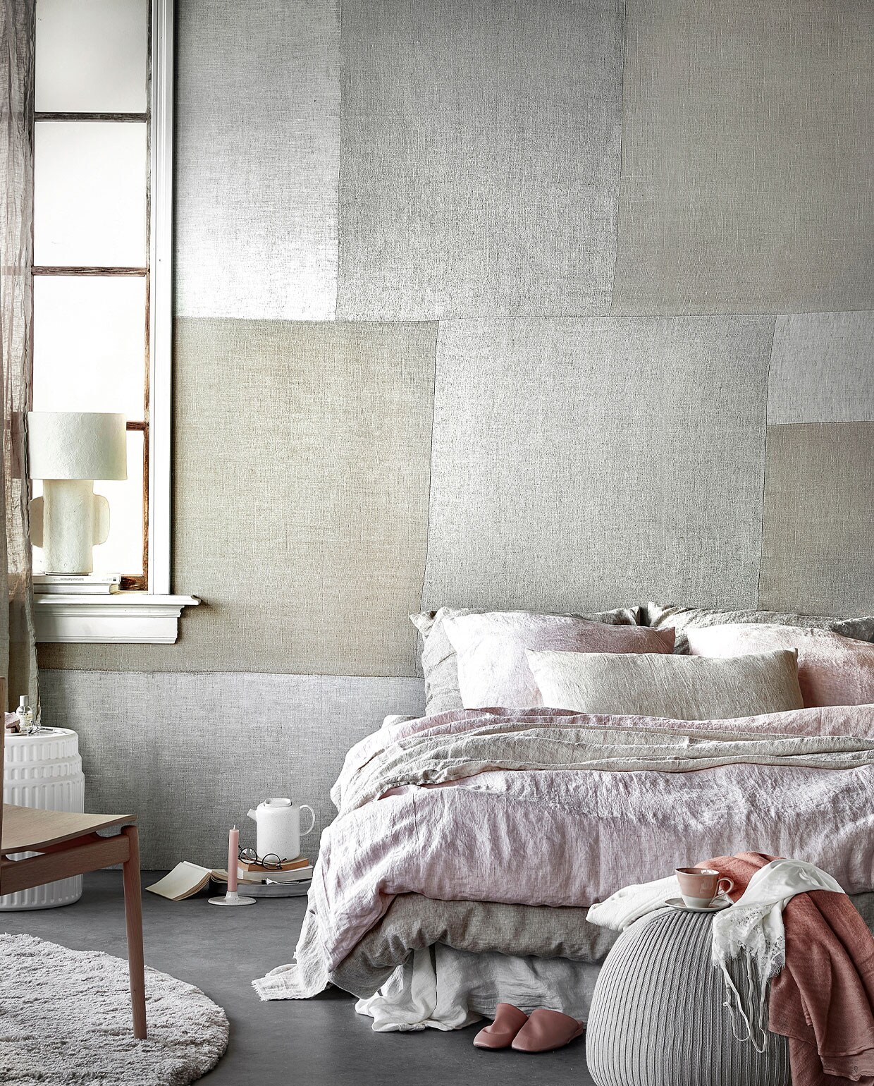Digitaal behang Patchwork Fabric, 6 banen van 280×50 cm, totaal (lxb) 280×300 cm € 149,-.M.m.v. hm.com (linnen gordijnen), paviljoennoord.com (papier-maché lamp, vest, roze shawl, kanten hemdje), kasstoor.nl (wit keramieken bijzettafel, rond vloerkleed), bolia.com (houten stoel, theepot), letoile.store (kandelaar), homestede.nl (betonnen schaal, poef), zara.com (roze kop-en-schotel, roze leren instappers), bymolle.com (wit laken in kleur Pure White, linnen dekbedovertrek in kleur Flax, linnen dekbedovertrek in kleur Blush, linnen plaid in kleur Sea Shell, linnen kussenslopen in kleur Blush en Flax), pure-original.nl (lakverf in kleur Ashes). Overig privébezit. vtwonen 05-2021 | styling Danielle Verheul | productie Tanja Saarberg | fotografie Peggy Janssen