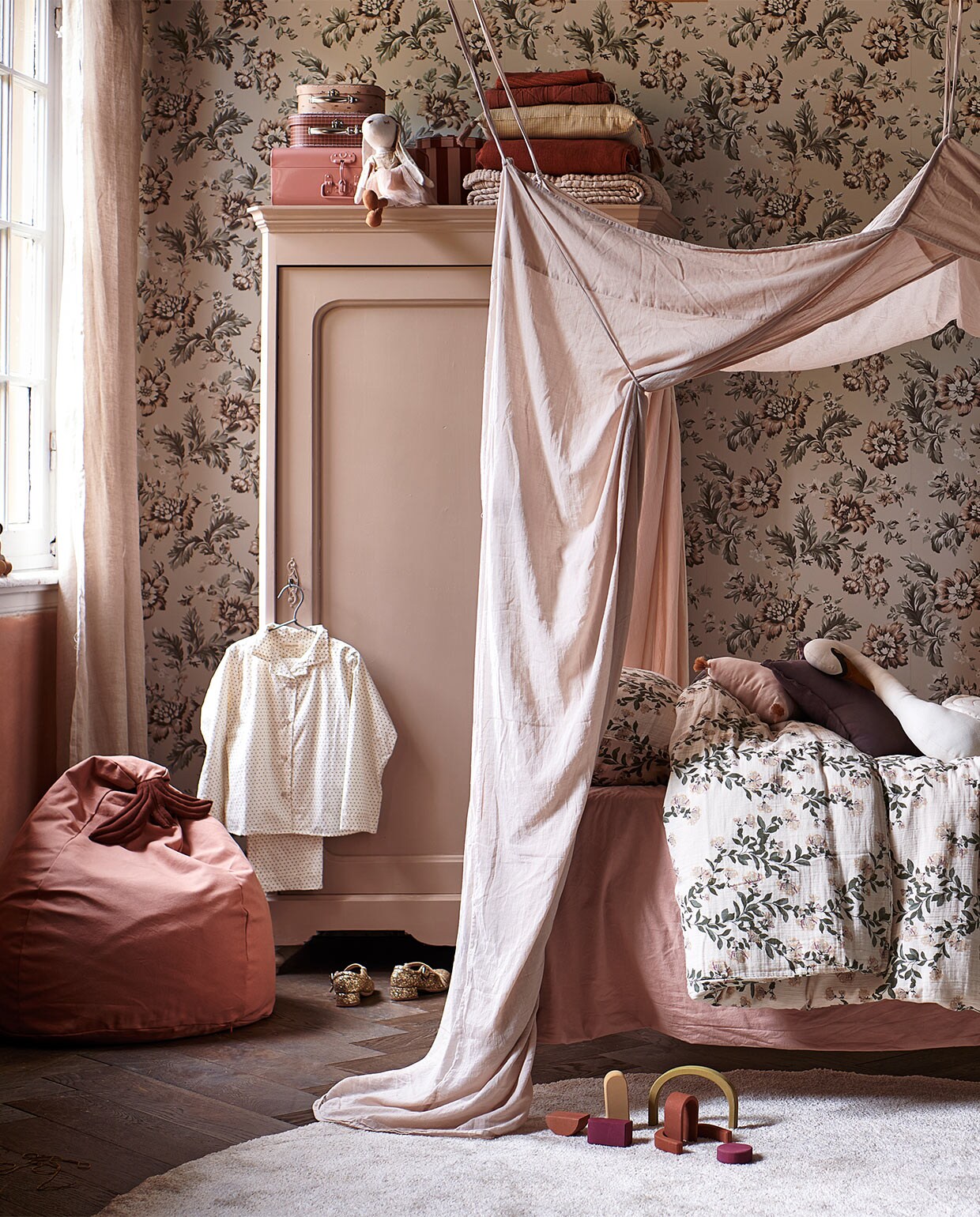 Juten vloerkleed Dots van Ferm Living (vtwonen.nl). Dekbed- overtrek Honeysuckle Muslin van Garbo &amp; Friends, 140×200 cm (lidor.nl). Kussen in vorm van huis Celia Mink van Camomile London, gevlochten opberg-mand appelvorm van Ferm Living, miniatuur-items van Maileg: roze houten bed, keuken, badkamerwastafel, ballet dance room met big sister mouse (storeofdaydreams.com). Mini-schommel (feloufamilyhouses.nl). Roze ronde poppenhuistafel (maileg.com). Zwarte ronde poppenhuisstoelen (ilovespeelgoed.nl). Knuffel konijn, houten poppenhuismeubels bed, kast en stoel (zarahome.com). Wanddecoratie ballon Byon Dusty small (psikhouvanjou.nl). Stof voor gordijnen, roze gewassen linnen (kniphal.nl). Vloer visgraat eiken bruin geolied van vtwonen (karwei.nl). JA | vtwonen special 13-2021 | styling Kim van Rossenberg | fotografie Sjoerd Eickmans