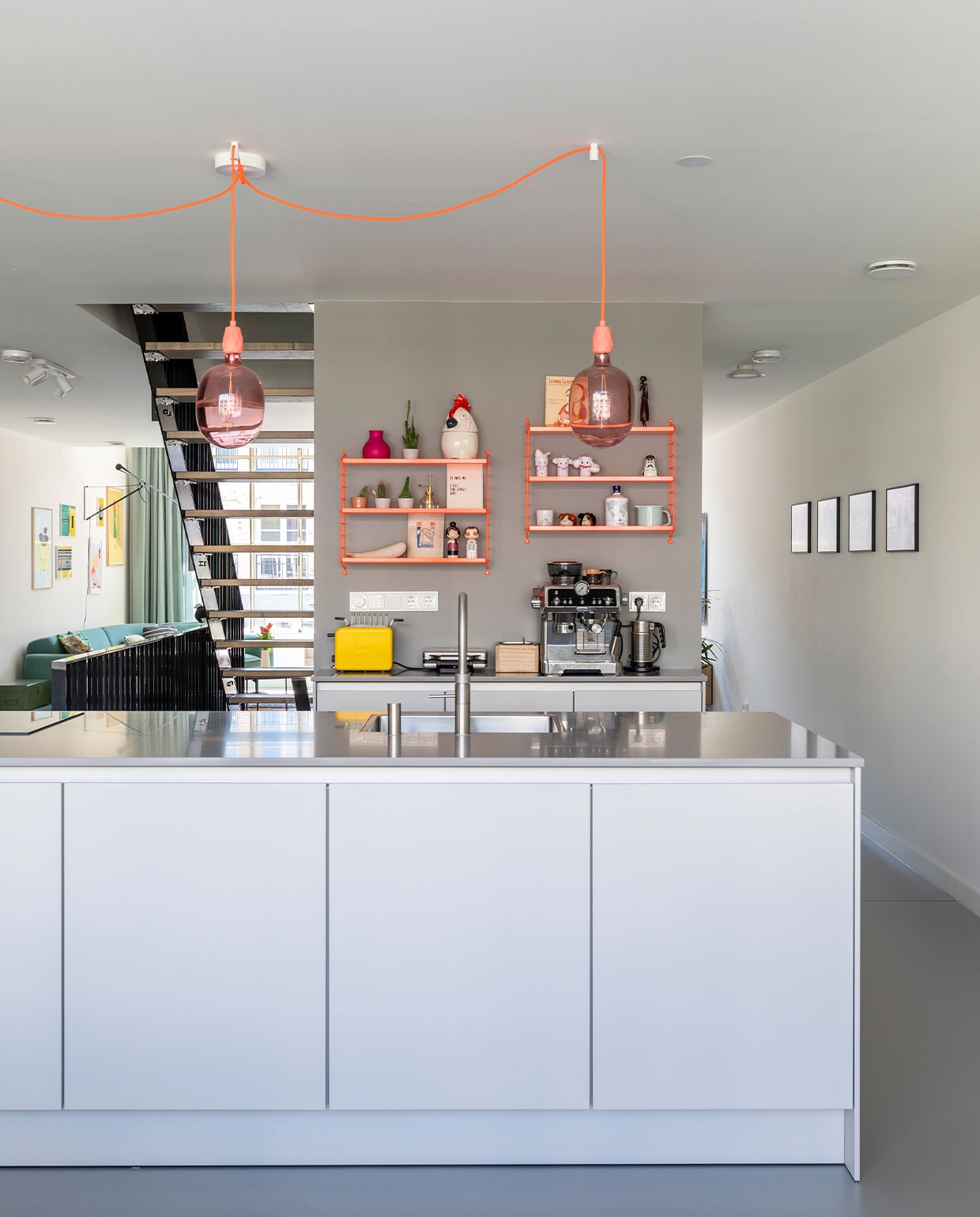 Kookeiland en keukenkasten (achterwand) Pure van Siematic in sterlinggrijs. Lampen Avesta van Calex, fittingen en snoeren van Snoerboer. Neon oranje wandrekken Pocket van String. Espressoapparaat DeLonghi. Kraan Quooker. Verf op de wand Lead van Little Greene. Voorraadpot Cockatoo van &amp;klevering, Kokeshi dolls Elton John en Amy Winehouse van Lucie Kaas, zoutvaatje Friends van Normann Copenhagen, broodrooster kMix van Kenwood, walvis gekocht op Elba, lang houten figuur uit Namibië, sneeuwpopjes knutsels van dochter Sien. vtwonen 03-2022 | fotografie Margriet Hoekstra
