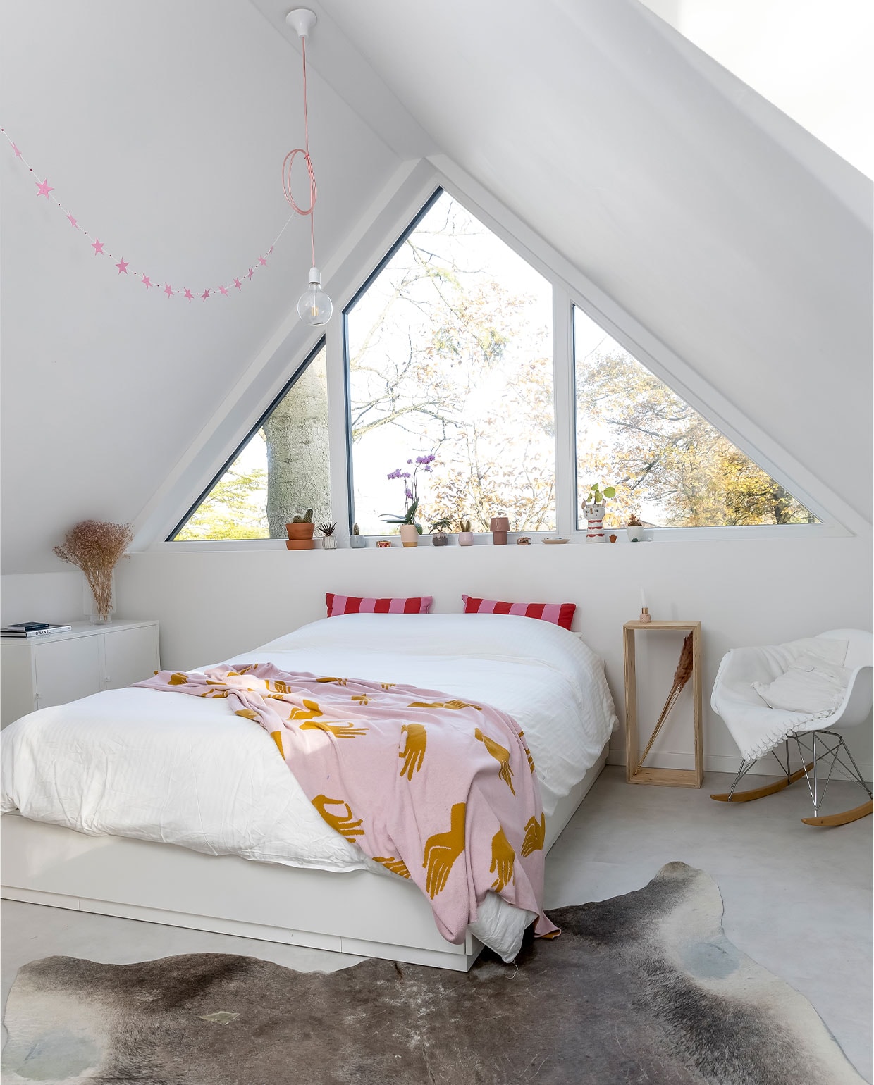 Kleed Marktplaats, kast, witte sprei en kussens Ikea, stoel Vitra, roze sprei Sissy-Boy, nachtkastje zelfgemaakt, plantenpotten Loods 5, vaas met droogbloemen Hema, lamp Snoerboer, slinger Jansje. vtwonen 04-2022 | fotografie Henny van Belkom