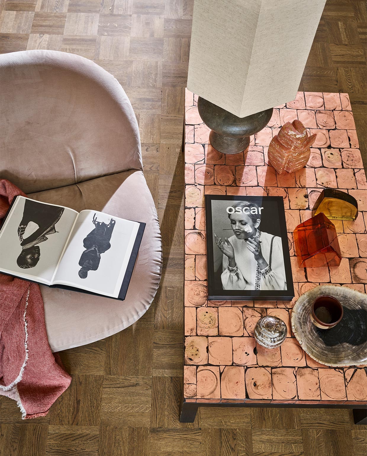 Fauteuil van Pierre Paulin voor Gubi (neeflouis.nl). Linnen plaid (couleurlocale.eu). Schemer- lamp, voet, kap, oranje glasobject, geel glasobject (hkliving.nl). Travertin beeld Wachter van Mirjam de Nijs, prijs op aanvraag (beeldenvansteen.nl). Salontafel, 111x62x34 cm (vintagehoarder.com). Boekop tafel Icons by Oscar (lannoo.be). JA vtwonen 09-2021 | styling Cleo Scheulderman | fotografie Jeroen van der Spek