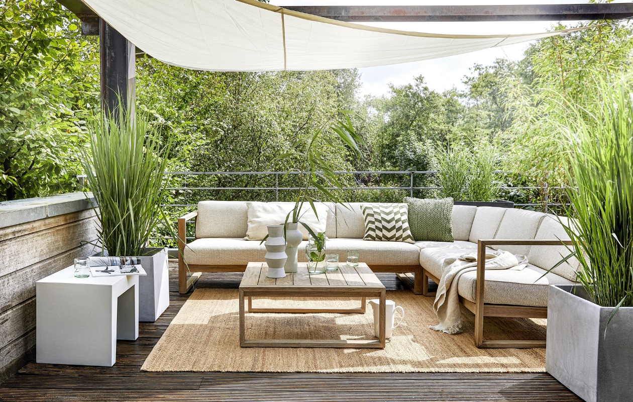 Loungebank die uit modules bestaat, links sofa 131 € 1429,-, rechts sofa 193 € 2049,-, hoekstuk Corner € 1025,-, salontafel set van 2 € 719,- (applebee.nl). Grijze kruk Concrete Seat van Fatboy € 119,- (vtwonen.nl). Lichtgrijze polyester plantenbakken Geneva van Cosapots, per stuk € 99,99 (praxis.nl). Hennep vloerkleed, 180x280 cm € 395,-, witte gespikkelde vazen Speckled Clay, per stuk € 39,95 (hkliving.nl). Glazen karaf € 7,50, glaasjes per stuk € 3,- (kwantum.nl). Groen gehaakt kussen € 14,99, groen-wit gedessineerd kussen € 24,99 (karwei.nl). Overig privébezit. vtwonen special tuin 6 | styling Moniek Visser | fotografie Peggy Janssen | styling assistentie Mirjam Gesink, Sanne Kiesling