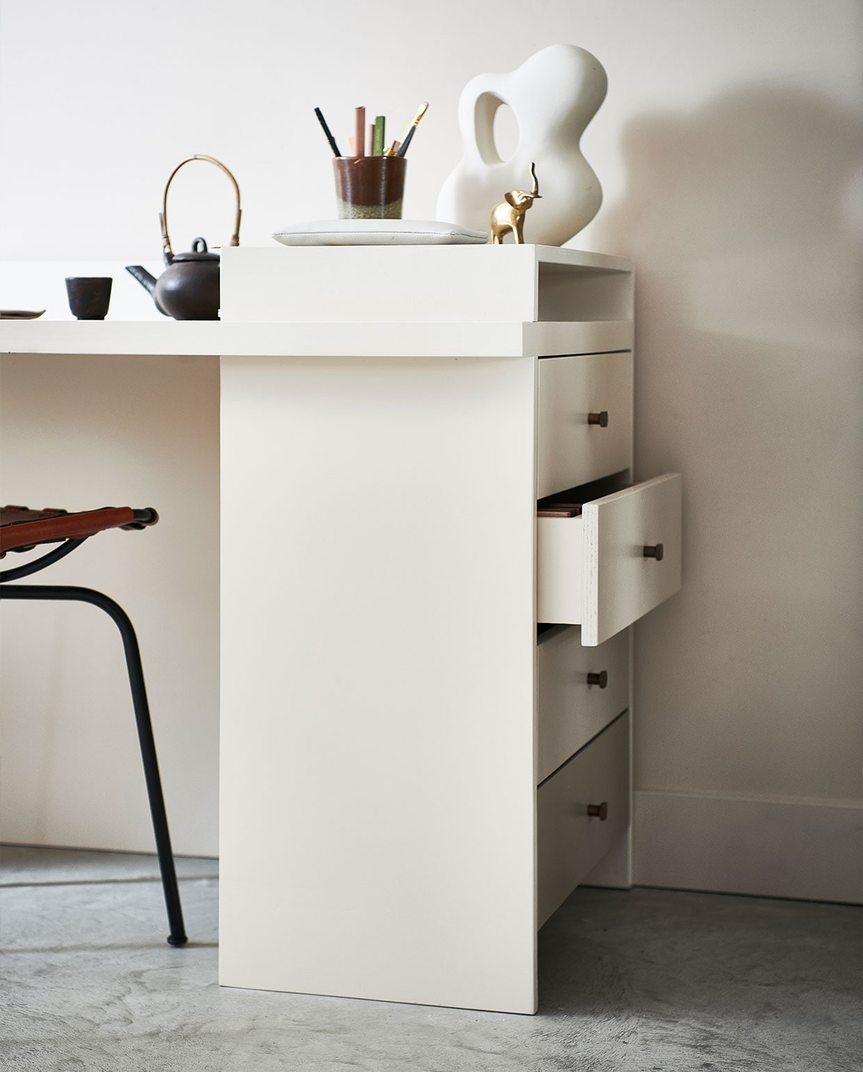 Verf op muur Mushroom nr. 142 (littlegreene.nl). Theepot met kopje € 35,99, bruin/groene mok € 15,99, groen/bruine aardewerken pot met kaars € 19,99, rond klein bordje, per stuk € 11,99, sisal vloerkleed, 160×230 cm € 279,- (zarahome.com). Organische decoratieve steen € 24,99 (hm.com). Gouden tafellamp Reflection van Bolia € 364,99 (vtwonen.nl). Overig privébezit. vtwonen 04-2022 | productie &amp; styling kim van rossenberg | uitvoering Richard van Meerveld | fotografie Sjoerd Eickmans\n