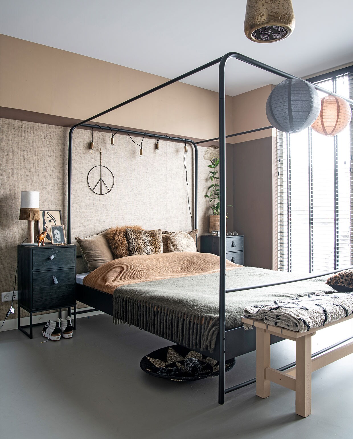 Gietvloer Evolve, hemelbed en nachtkastje Woood, plaid Go Round, kussens J-Line, dekbed H&amp;M, bankje voor bed Marktplaats net als de wanden geverfd met matte Amazona krijtverf kleur Skin, behang Eijffinger, peaceteken Evenaar, raambekleding Ilumio. Gouden slingerlampjes Karwei, lampionnen AliExpress, lamp Zenza, lijst Housevitamin, poster in oude lijst is schoonmoeder, gemaakt door haar broer, beeld uit Tanzania, mand onder bed Manggis Living, plantenpot uit eigen winkel, merk onbekend. Overig allemaal uit eigen winkel. vtwonen 3-2022 | productie Insidehomepage | styling Esther Loonstijn | fotografie Louis Lemaire