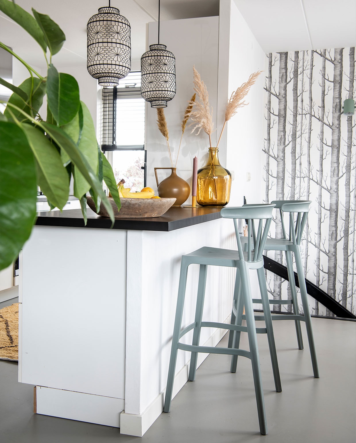 Barstoelen Woood, vloerkleed en gele vaas HKliving, gietvloer Evolve, keuken vorige bewoner, lampen Dutchbone, behang Cole and Son. Fruitschaal Raw Materials, kandelaar Branded, kaarsen Rustik. Bruine vaas onbekend. vtwonen 3-2022 | productie Insidehomepage | styling Esther Loonstijn | fotografie Louis Lemaire