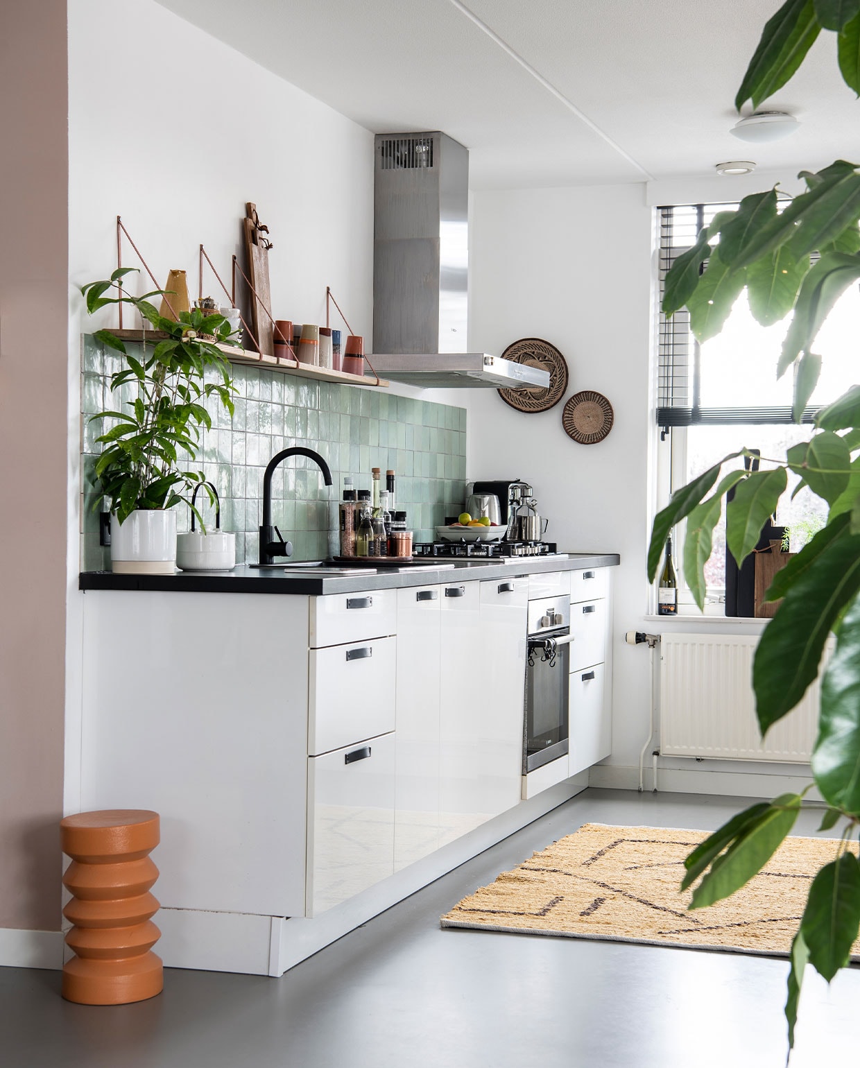 Muurkleur Zeester van Flexa, gietvloer Evolve. Tegels Jan Groen, keuken vorige bewoner, leren handgrepen en eiken- houten plank van Handles en more, oranje bijzettafel, houten planken, kleed en latte mugs HKliving, vaas Sissy Boy. Plantenpotten Gina Da, wanddecoratie uit Afrika. Raambekleding Ilumio. vtwonen 3-2022 | productie Insidehomepage | styling Esther Loonstijn | fotografie Louis Lemaire | tekst Inge Van Lieshout | tekstbewerking Mirjam Rosema-Verhulst