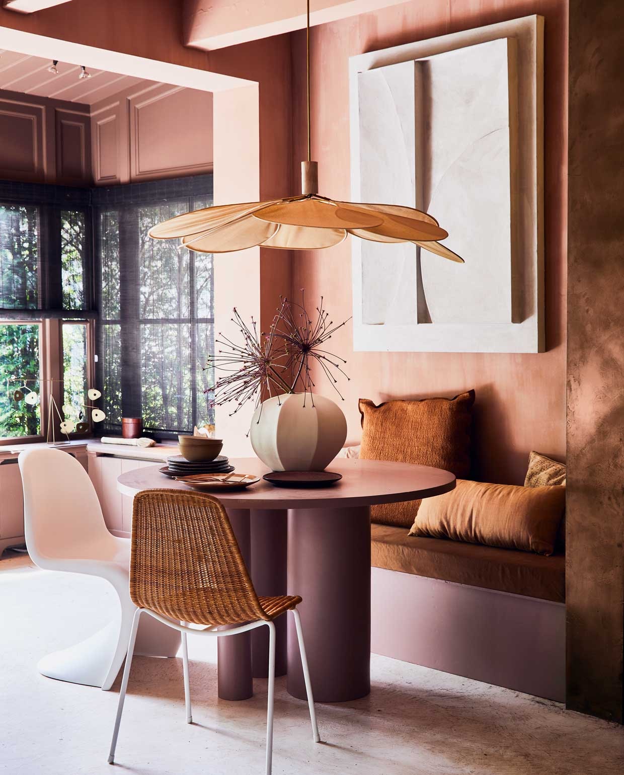 Muur in kalkverf Cypria van Carte Colori, per liter € 48,- (brechtmurreatelier.nl). Ronde eettafel vanaf € 650,- en ingebouwde eetkamerbank met matraskussen vanaf € 500,- (com-anders.nl).Stoel Panton Chair van Vitra € 279,-, witte vaas Cyrus van Urban Nature Culture, 30x38 cm (hxØ) € 119,-, dinerbord Earth uit de 70’s-serie van HKliving, Ø 29 cm € 14,05, kom uit de Bold & Basic-serie van HKliving, Ø 16,5 cm € 14,95, bordeaux dinerbord uit de Bold & Basic-serie van HKliving, Ø 29 cm € 19,95, stapel taupe ontbijtborden uit de Gradient Ceramicsserie van HKliving, Ø 22,5 cm per stuk € 12,10, koperkleurige bestekset uit de Vintage-serie van Amefa, 24-delig € 49,99 (vtwonen.nl). Hanglamp Suspension Pale, Ø 100 cm € 219,-, stoel Basket Chair Rattan € 385,-, groot terracotta kussen 60x60 cm vanaf € 156,-, oudroze kussen € 99,- (couleurlocale.eu). Langwerpig terracotta kussen, 30x70 cm € 18,- (gabrielle-paris.com). Messing mobiel op vensterbank € 169,- (maisonnl.com). Zandkleurig kunstwerk prijs op aanvraag (artinreturn.nl). Overig privébezit. vtwonen 09-2020 | styling Cleo Scheulderman | fotografie Jeroen van der Spek