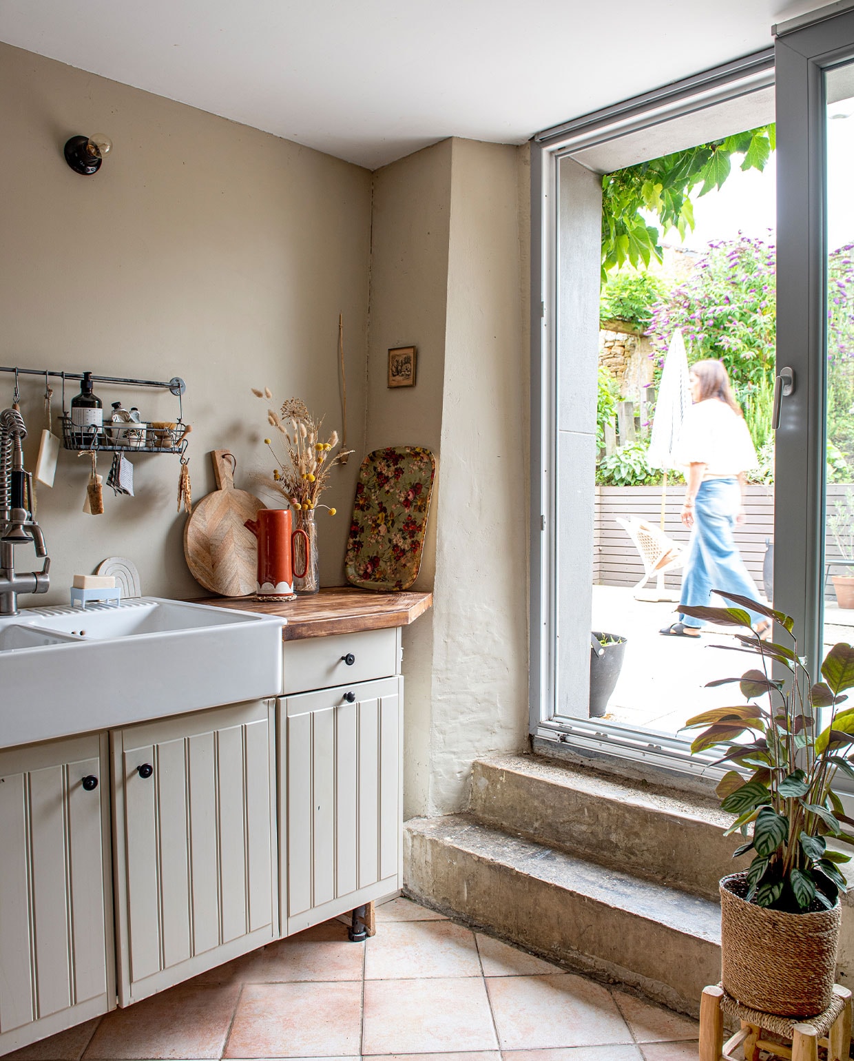 Keuken Ikea, muurlamp Zangra, wandrek Ikea, plank, dienblad en lijst vintage, schenkkan Portugees aardewerk via Chez la Fille du Boucher, plantenmand Jardiland, kruk vintage, de vloertegels lagen al in het huis. vtwonen 3-2022 | productie De Binnenkijkers | styling Jeske Weel | fotografie Caroline Coehorst | tekst Chris Muyres