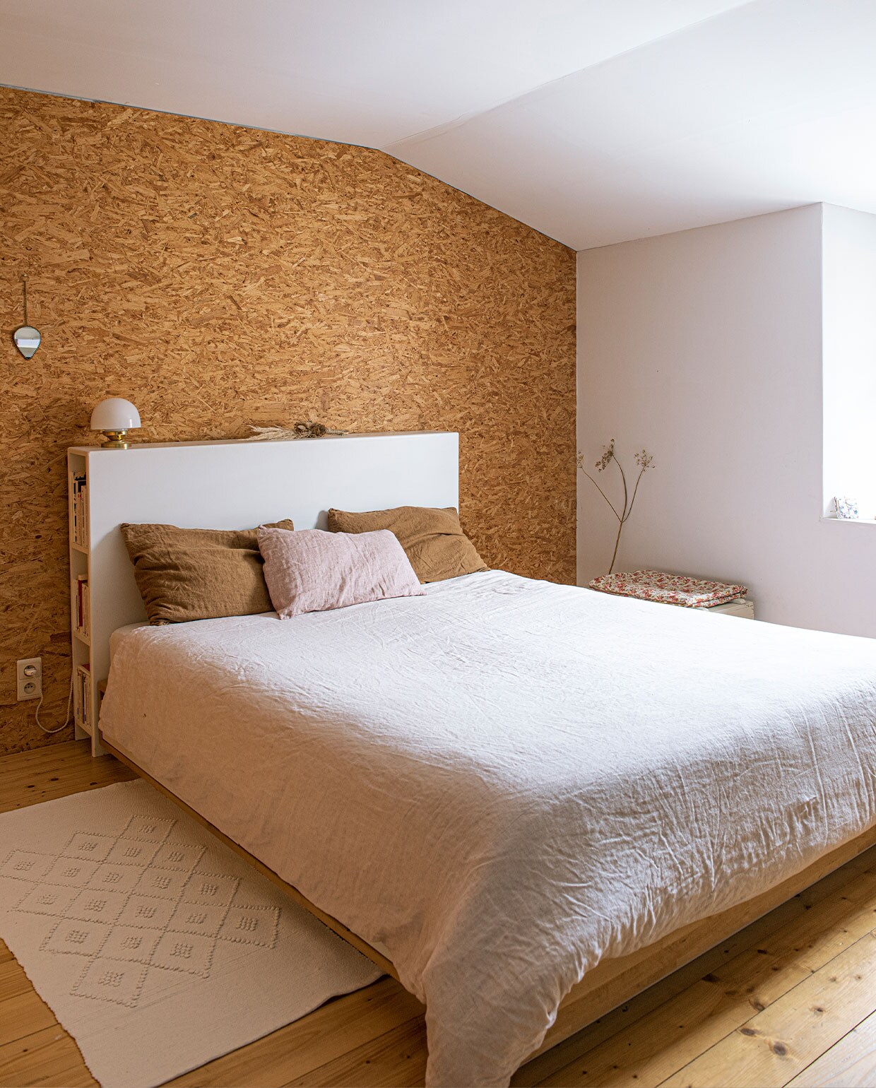Hoofdeinde bed gemaakt door Kevin, linnen kussenhoezen en dekbedovertrek By Mölle, muur afgetimmerd met OSB-plaat, karpet uit Portugal, vintage spiegel, vloer van grenen planken. vtwonen 3-2022 | productie De Binnenkijkers | styling Jeske Weel | fotografie Caroline Coehorst | tekst Chris Muyres