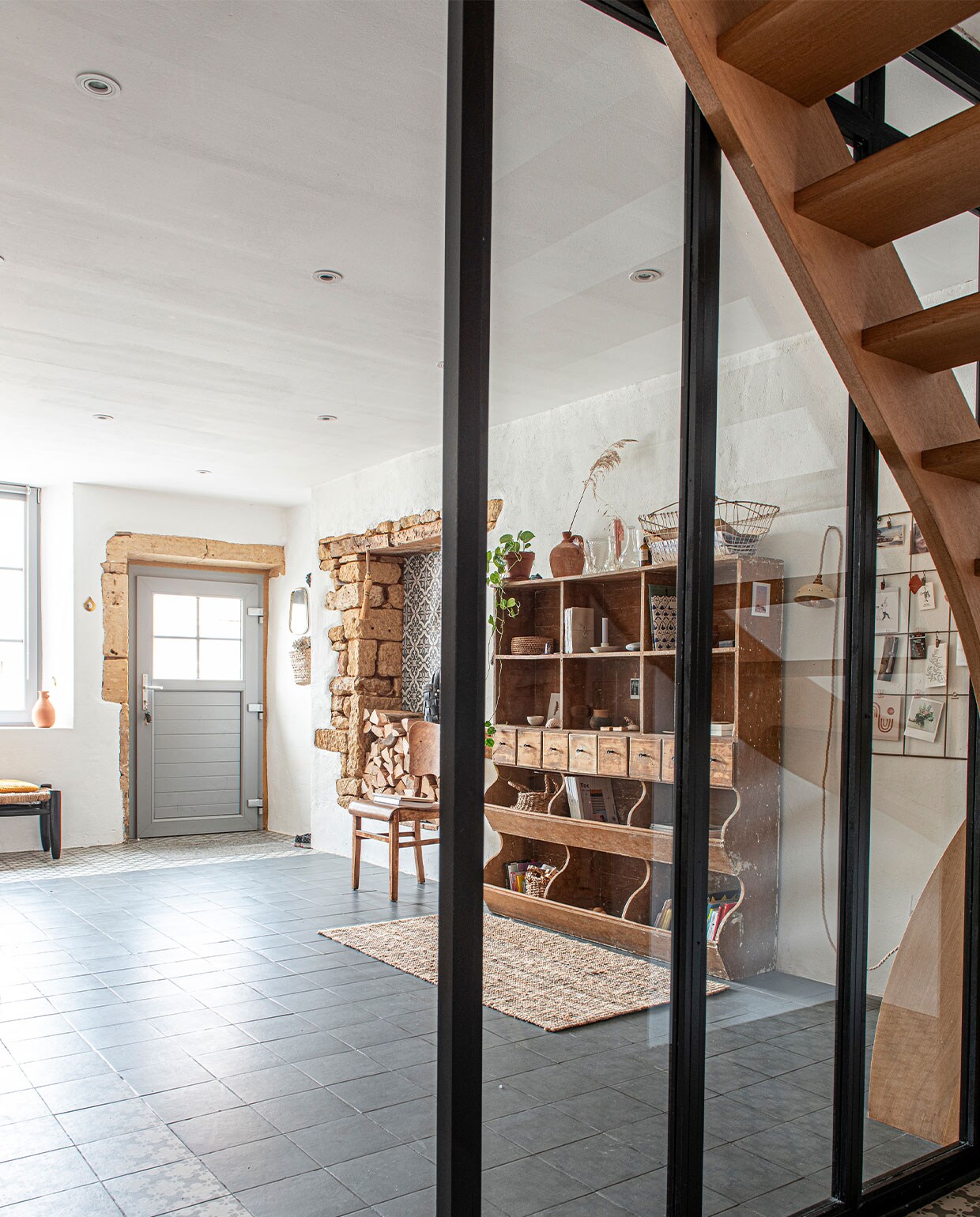 Antieke kruidenierskast, daarop vintage potten, glaswerk en mand, vintage stoel, karpet Ikea, vloertegels collectie Azulej van Mutina, kruk onder raam Couleur Locale (Knokke), vaas in raam van lokale bloemist, kaarthouder Madam Stoltz, muurlamp zelfgemaakt. vtwonen 3-2022 | productie De Binnenkijkers | styling Jeske Weel | fotografie Caroline Coehorst | tekst Chris Muyres