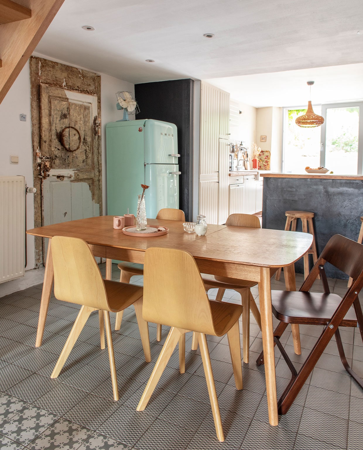 Tafel en stoelen La Redoute, vloertegels collectie Azulej van Mutina, keuken Ikea, vintage hanglamp via La Lune Decoration, koelkast Smeg, vintage ventilator, klapstoel Fameg, kruk Ikea, vintage glaswerk, mokken en dienblad HKliving. vtwonen 3-2022 | productie De Binnenkijkers | styling Jeske Weel | fotografie Caroline Coehorst