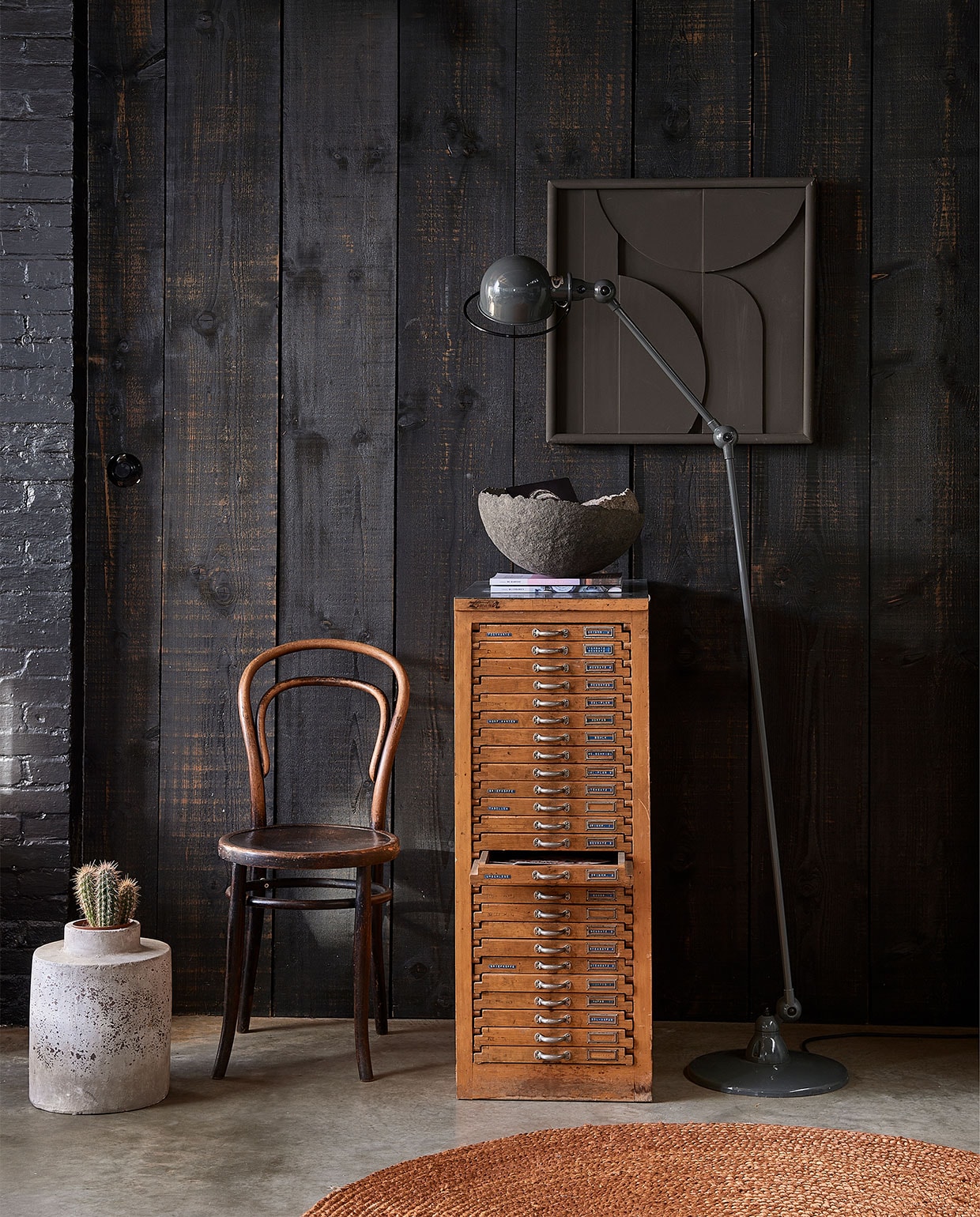 Houten ladenblok € 375,- (vandijkenko.nl). Staande lamp Jieldé, prijs op aanvraag (fensdecor.nl). Thonet stoel € 195,- (neeflouis.nl). Abstract schilderij Fiona, 60×60 cm € 149,- (deeekhoorn.com). Bakken van papier-maché vanaf € 65,- (boxworx.nl). Rond vloerkleed Ross, 150 cm (Ø) € 79,95 (fonq.nl). vtwonen 3-2022 | Styling Fietje Bruijn | Fotografie Dennis Brandsma\n
