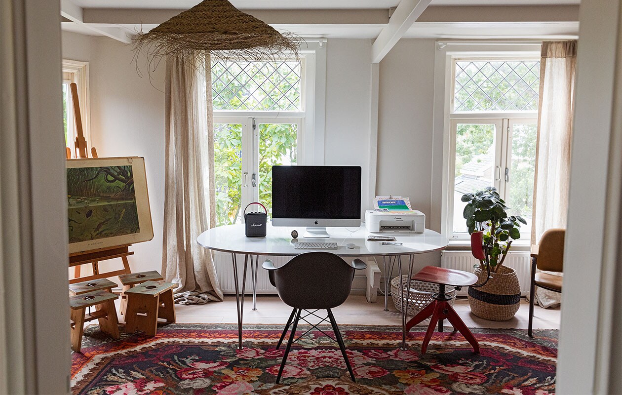 Bureau Fritz Hansen. Stoel Eames via Vitra. Rozenkelim Raw Materials. Melkkrukken eigen ontwerp Isi i.s.m. Geralt Ploegstra. Schoolplaat In sloot en plas antiquair. Lamp Household Hardware. Muziekbox Marshall. Eikenhouten vloer met whitewash olie Parketservice Alkmaar. Wand en plafond kleur Porcelain Mould van Flexa. Fotolijst van oma. Schildersezel Mabef. Gordijnroede zelfgemaakt. Gordijn herkomst onbekend. vtwonen 2-2022 | styling Ilona Jongepier | fotografie Dana van Leeuwen