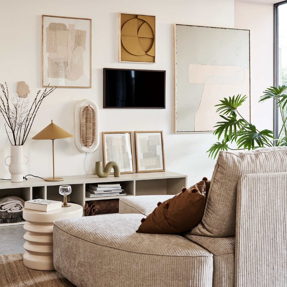 Televisie The Frame 32 inch € 429,-, verwisselbare walnoothouten lijst The Frame € 129,- (samsung.nl). Kast in kleur Skimming Stone 241 van Farrow &amp; Ball AFMETING € XXX,- (combitex.nl). Handgemaakte ovalen wandlamp NAAM € 299,- (lanena-home.com). Sofa Hunter bestaat uit diverse losse onderdelen: poef € 419,-, element met rug € 1009,-, element zonder rug € 419,- (zuiver.nl). Bruin sierkussen met pompons van MERK € 29,95, roze bijzettafel van MERK € 159,-, vaas van MERK AFMETING € 47,95 (vtwonen.nl). Hennep vloerkleed 180×280 (bxl) € 395,-, olijf/nude-kleurig abstract kunstwerk (rechts) 100×120 cm (bxh) € 549,-, okergeel kunstwerk boven tv van 43x4x53cm (bxdxh) € 329,-, taupekleurig wandornament Face € 37,95, crèmekleurige bijzettafel 38×36 cm (Øxh), wijnglazen met groene voet € 9,95, okergele lamp Triangel € 149,- (hkliving.nl). Stoffen kunstwerk in eikenhouten lijst € 89,-, kunstwerken in lijst op kast, per stuk € 69,- (sur-atelier.nl). Bruine en beige katoenen plaids in dressoir 130×170 cm per stuk € 45,99 (zarahome.com). Donkerbruin plaid rechts in dressoir 130×170 cm (bxl) € 65,- (maisonnl.com). Overig privébezit. vtwonen 02-2022 |  Styling Esther Jostmeijer | Fotografie Bart Brussee