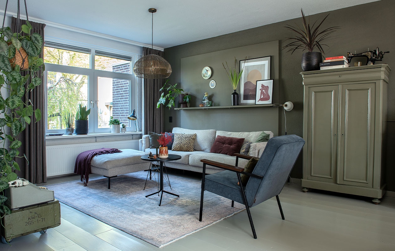 Muurverf Camouflage van Flexa. Bank Cosy Villa van Casba Wonen. Stoel Karwei, tafel Trampoliere van Midj. Kast, grote vaas en borden kringloop. Hanglamp Light &amp; Living, vloerkleed Volero. Posters Desenio. Bloempot op wandplank Jysk. Kussen tijgerprint van Goround, bordeauxrood van Mrs. Bloom. Klemspot Ikea, oranjerode vaas Madam Stoltz. Bureaulamp, Chinese vogel en vis van de groothandel. Overig onbekend. vtwonen DIY special 4 | fotografie Ton Bouwer | productie Monique van der Pauw