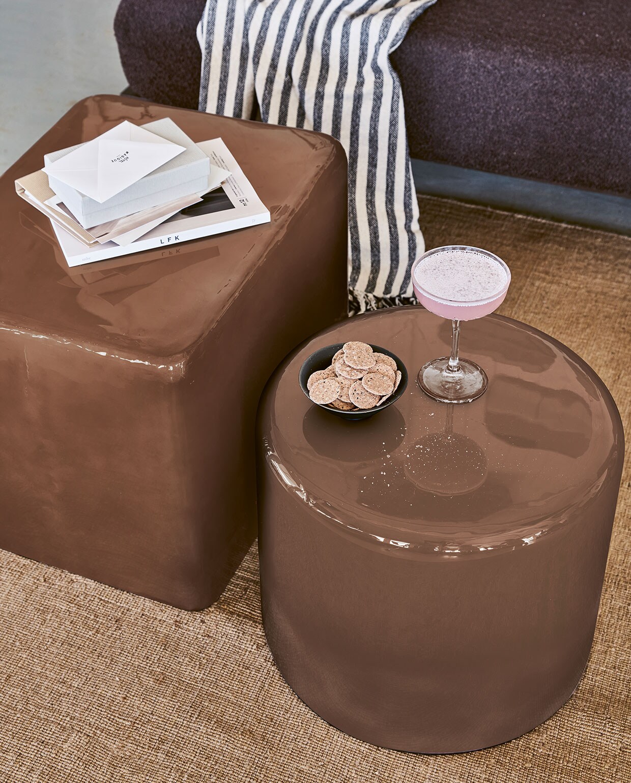 Roségoudkleurige metalen bijzettafel/poef, rond 43×36 cm (Øxh) € 149,-, rechthoekig 36x43x55 cm € 199,- (hxbxd). Zwart-wit gestreepte plaid van chambray met geknoopte franjes, 130×170 cm (bxl) € 49,95.M.m.v. Karwei (vloerkleed van vtwonen). Overig privébezit. vtwonen 04-2022| Productie Tanja Saarberg | Styling Marlies Does | Fotografie Bart Brussee