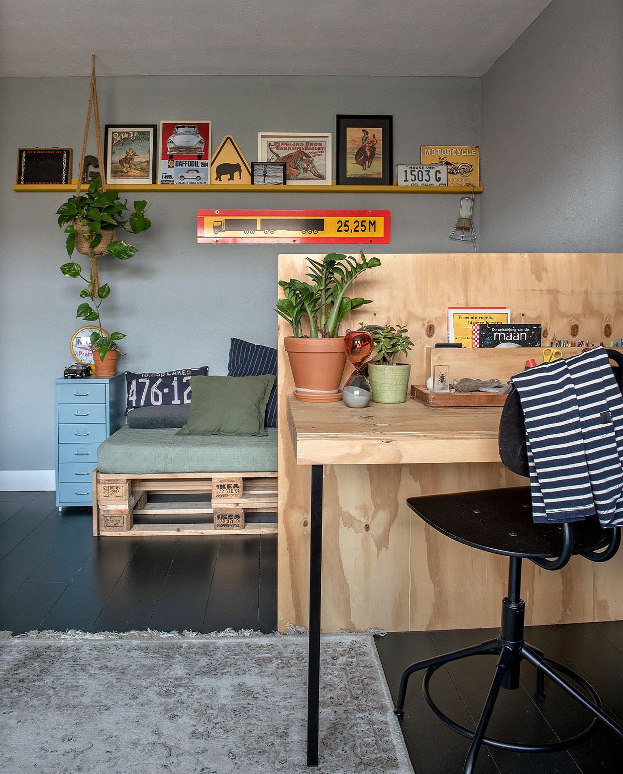 Verf vloer Kaviaar van Histor, wand Pastelblauw van Karwei. Chillbank gemaakt van pallets en een matras bekleed met een deken van Kwantum. Kleed Karwei, bureaustoel, ladekast, klemlamp Ikea. Nummerbord USA, klok Loods 5. Zandloper Leen Bakker. Plantenpotten Intratuin. Op de wandplank pagina’s gescheurd uit een oud circusboek. Langwerpige vrachtwagen via Bas’ werk. Overig onbekend. vtwonen DIY special 4 | Fotografie Ton Bouwer | Productie Monique van der Pauw