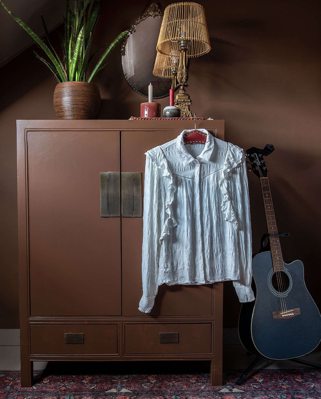 Verf wand- en kast bruin IG PS 1051 van Karwei. Chinese kast, lamp en spiegel van de kringloop. Kleed Leen Bakker. Plantenpot Intratuin. Kandelaars onbekend. Gitaar Richwood.. vtwonen DIY special 4 | Fotografie Ton Bouwer | Productie en tekst Monique van der pauw
