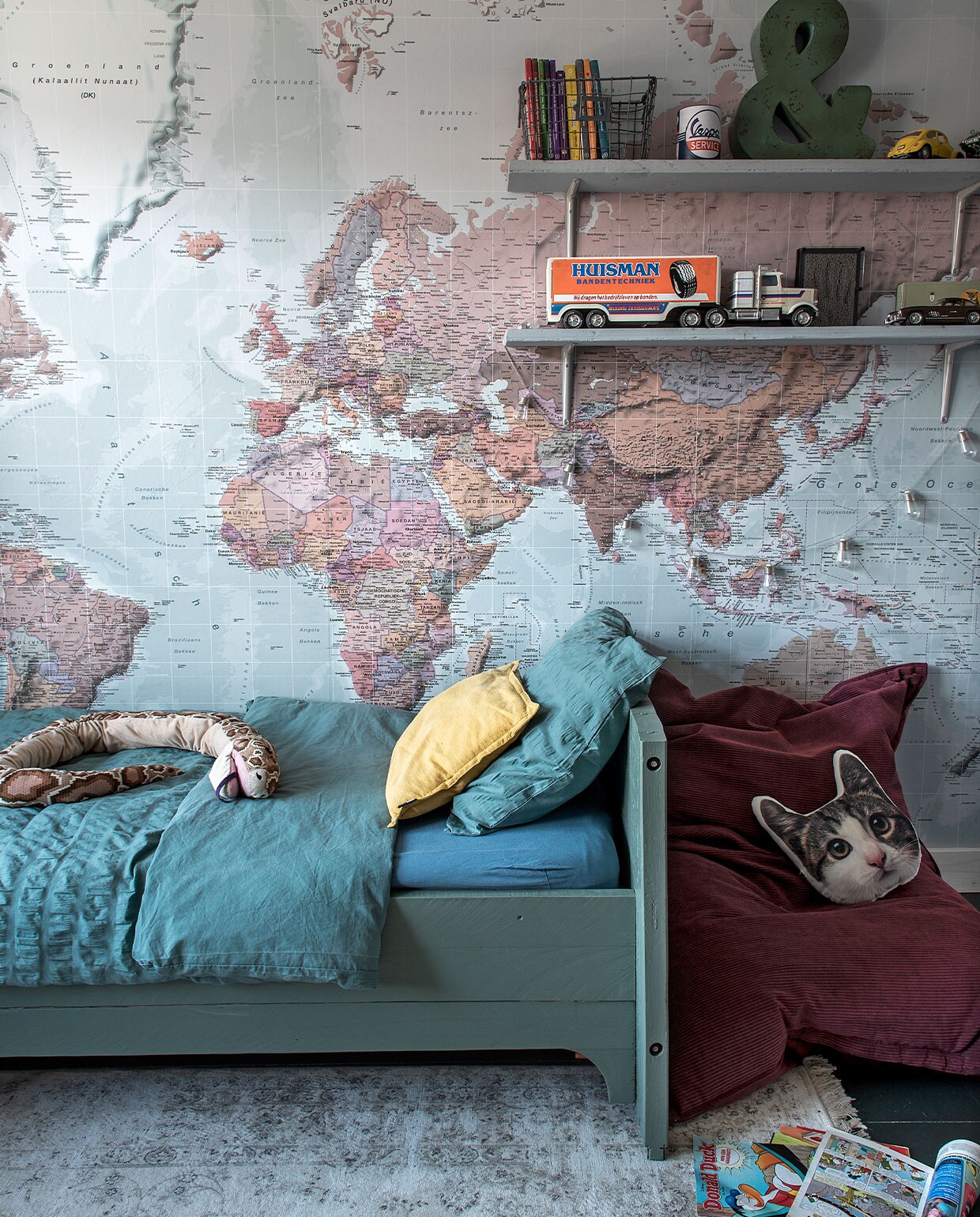 Bed zelfgemaakt van oude planken, kleur verf bed onbekend. Behang wereldkaart Photowall. Bedlinnen Jysk. Slang Ikea, kussen kat Zeeman, zitzak Leen Bakker, draadmand en &amp;-teken Loods 5. Vrachtwagen via Bas’ werk, oude auto’s van Bas. Overig onbekend. vtwonen DIY special 4 | Fotografie Ton Bouwer | Productie Monique van der Pauw