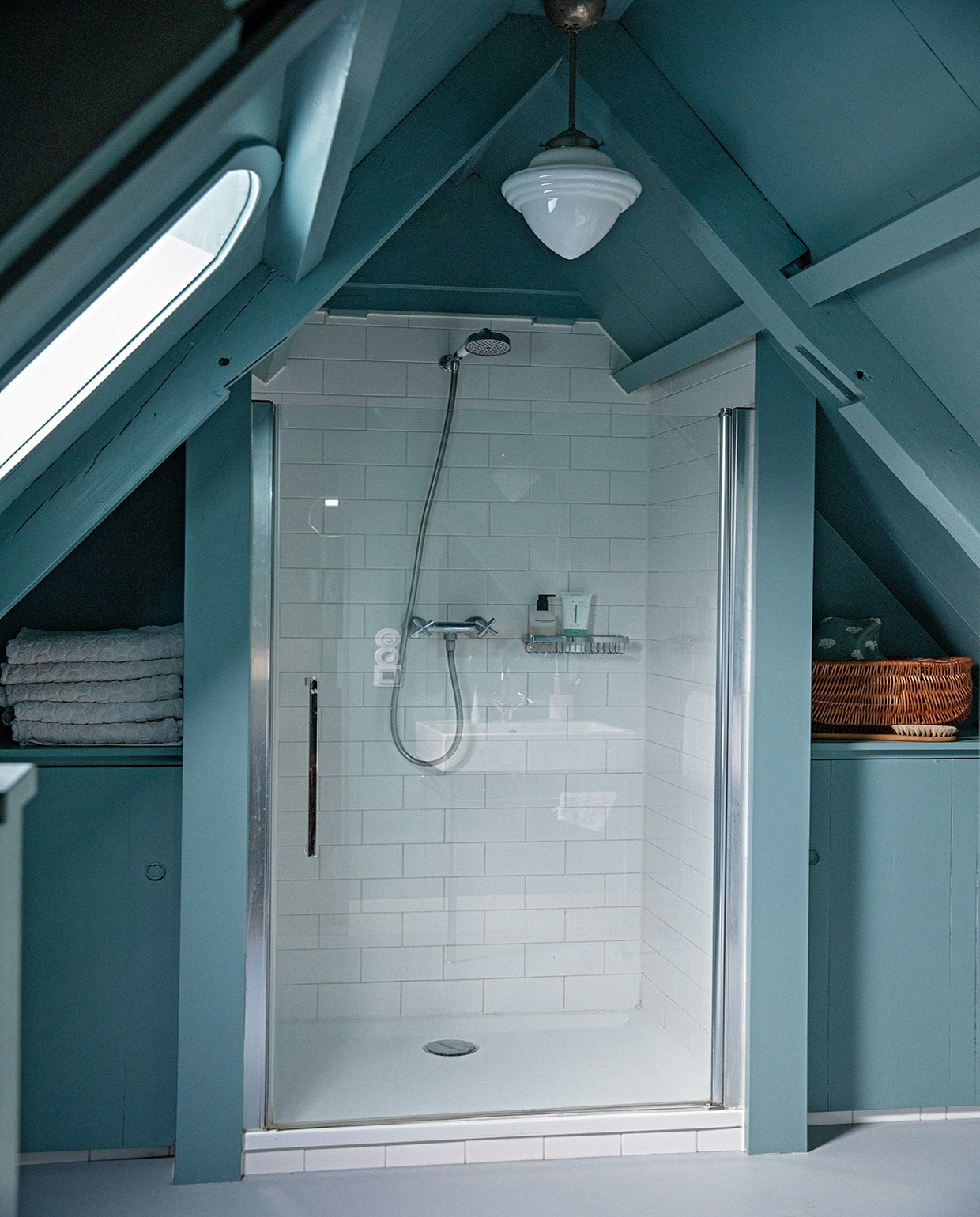 Muurverf Oval Room Blue van Farrow &amp; Ball, lamp Gispen, tegels herkomst onbekend, handdoeken Hema. Mand is een oude poppenwieg. Borstel Iris Hantverk. vtwonen 05-2021 | productie &amp; styling Ilona Jongepier | fotografie Dana van Leeuwen