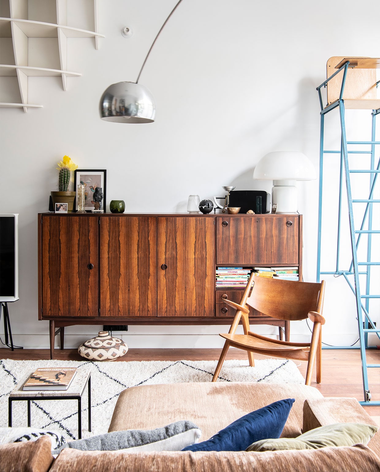 Bank Arketipo, lounge chair Hans Wegner, bijzettafel onbekend. Flos Arco booglamp, berberkleed, scheidsrechtersstoel Marktplaats. Design bolkast gekregen van de ouders van Bob. Dressoir, mushroom lamp van Elio Martinelli Marktplaats, oliebrander Aesop, brievenweegschaal en vintage glazen stolp met vleermuis souvenirs New York. Vintage bloempot DasGaaf, bloemen op sterk water in glazen erlenmeyer Het Grote Avontuur, 3D puzzel astronaut Tenue de Nîmes, waxinelichthouder Iittala, print van Dieter Braun Juniqe. Mand souvenir Bali. vtwonen 02-2022 | productie Insidehomepage | styling Kim Timmerman | fotografie Louis Lemaire
