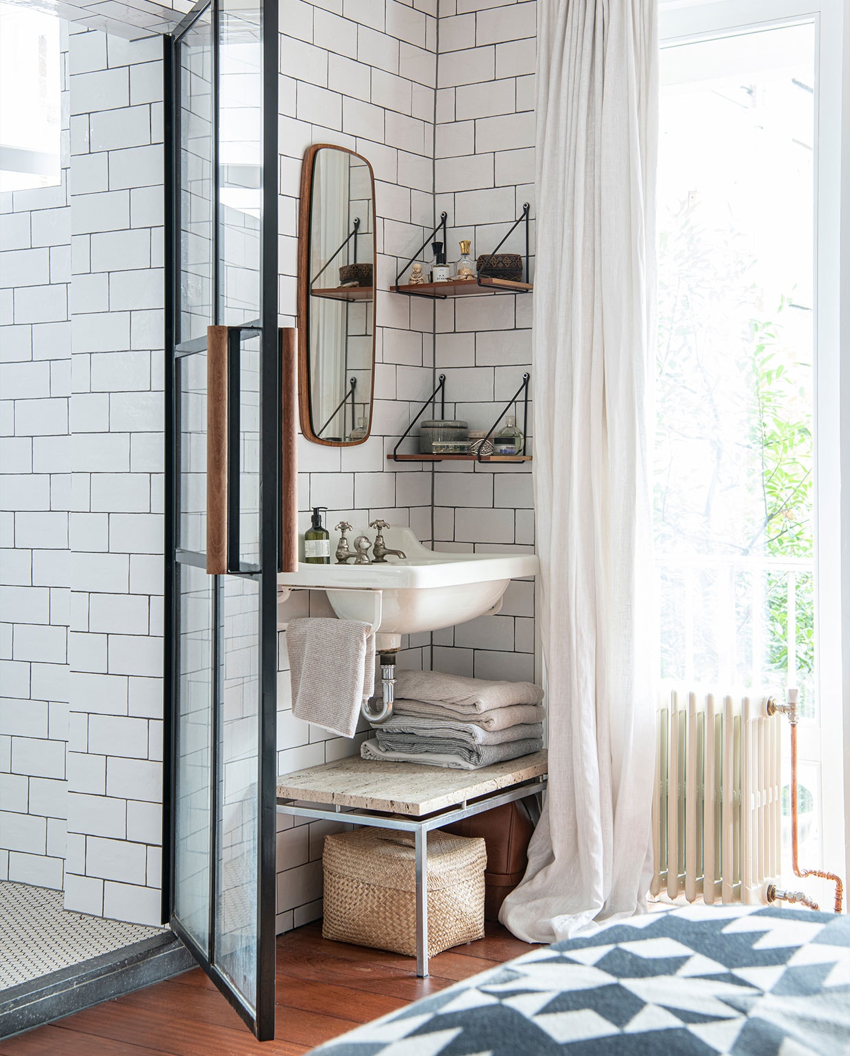 Metrotegels Meester Smeets, stalen deur La Bolleur. Wastafel vintage uit een oud huis, zeepdispenser Arket, spiegel Marktplaats, wandplanken zelfgemaakt. Vintage marmeren tafel Marktplaats, handdoeken Zara Home, mand H&amp;M Home. Linnen gordijnen op maat laten maken, deken Pendleton. vtwonen 02-2022 | productie Insidehomepage | styling Kim Timmerman | fotografie Louis Lemaire | tekst Inge van Lieshout