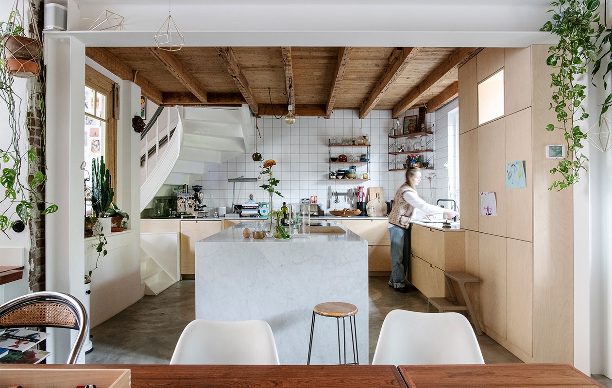 Keukenkast maatwerk, fronten Plykea, kookplaat Bora. Kookeiland en aanrecht Wessels Natuursteen. Witte tegels Meester Smeets, voeg antraciet Forbo. Koffiemachine VBM, bonenmaler Quamar, speaker Sonos, diamantlamp Dazor, weegschaal souvenir Cambodja, magnetisch messenrek Global Knives, roze beertje Bearbrick collectible, fruitschaal souvenir Suriname, vintage wandrek Tomado Marktplaats, broodplanken onbekend. Kraan Quooker. Opstap/kruk Ikea. Vintage kruk en Tulip Chairs Marktplaats, eetkamerstoel onbekend. Prullenbak Vipp. Masker souvenir Indonesië. Hexagon hanger Combo Design. Gietvloer met vloerverwarming. vtwonen 02-2022 | productie Insidehomepage | styling Kim Timmerman | fotografie Louis Lemaire