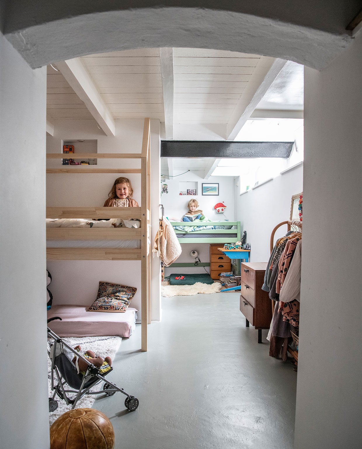 Ondervloer geïsoleerd met garageverf. Blankhouten bed Petit Puk, matras uit ledikant bekleed met hydrofiele doek Yumi Baby, kussen souvenir Turkije, vloerkleed H&amp;M Home, leren bal vintage. Groen bed Hoppekids, paddenstoelenlamp door opa en oma gemaakt, schapenvacht Ikea, ladekast erfstuk, bureau op straat gevonden. Kledingrek Zara Home, jaren 50 ladekast Marktplaats. vtwonen 02-2022 | productie Insidehomepage | styling Kim Timmerman | fotografie Louis Lemaire