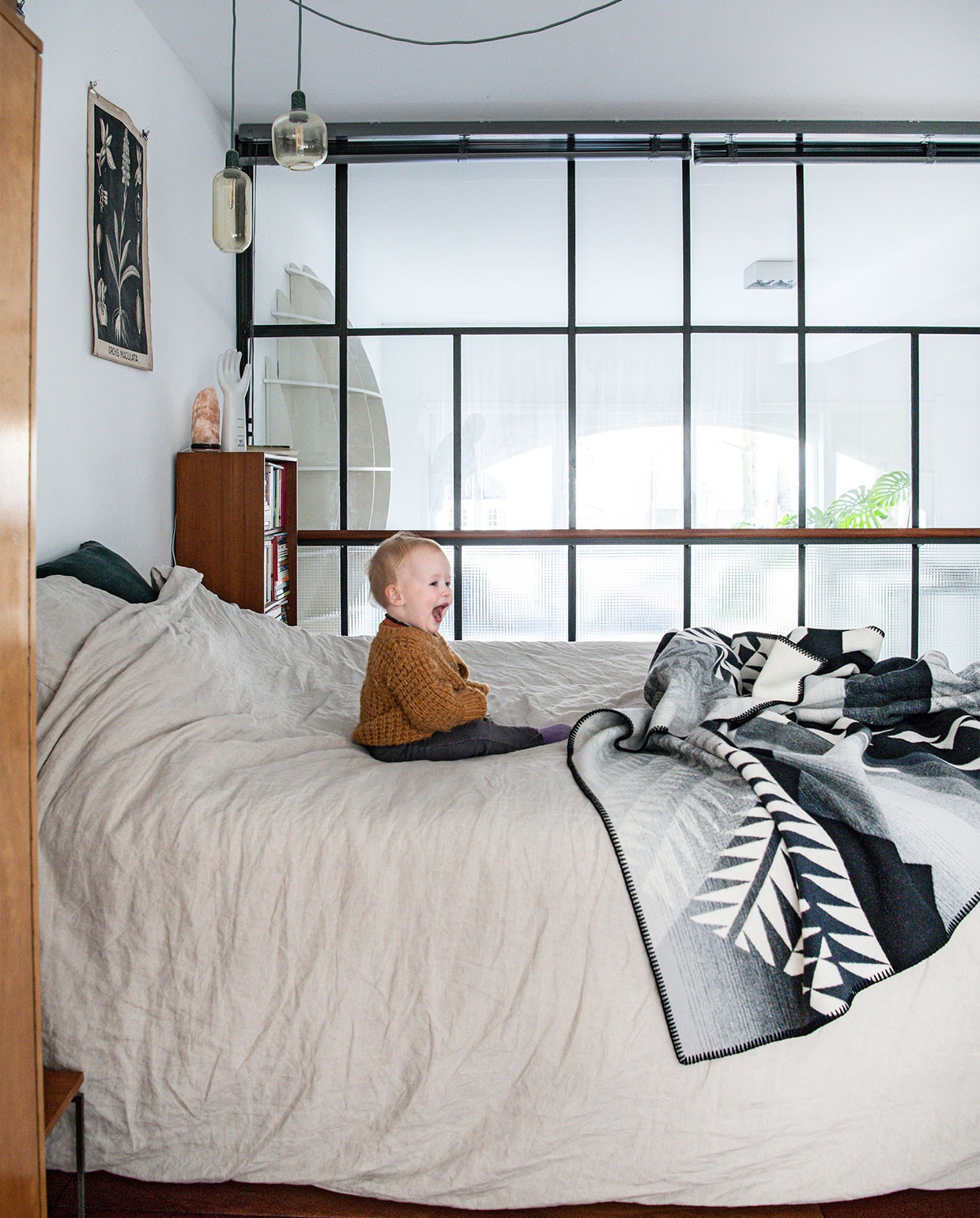 Vloer van tropisch hardhout lag er al, glazen wand La Bolleur, raambekleding Luxaflex. Boekenkast, vintage hand­schoenenmal, vintage schoolplaten Marktplaats, Himalaya zoutsteen Ziloen. Hanglamp Normann Copenhagen. Bed Auping, beddengoed Yumeko, deken Pendleton. vtwonen 02-2022 | productie Insidehomepage | styling Kim Timmerman | fotografie Louis Lemaire